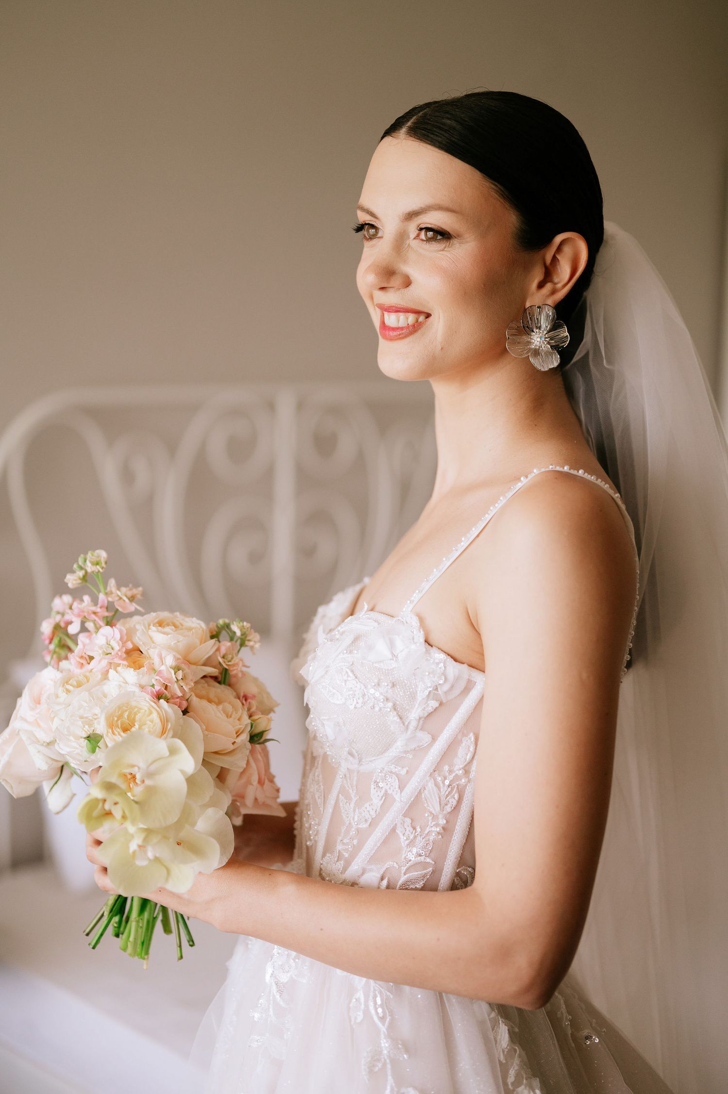 Elegant bridal portrait featuring classic white gown and romantic pastel bouquet.