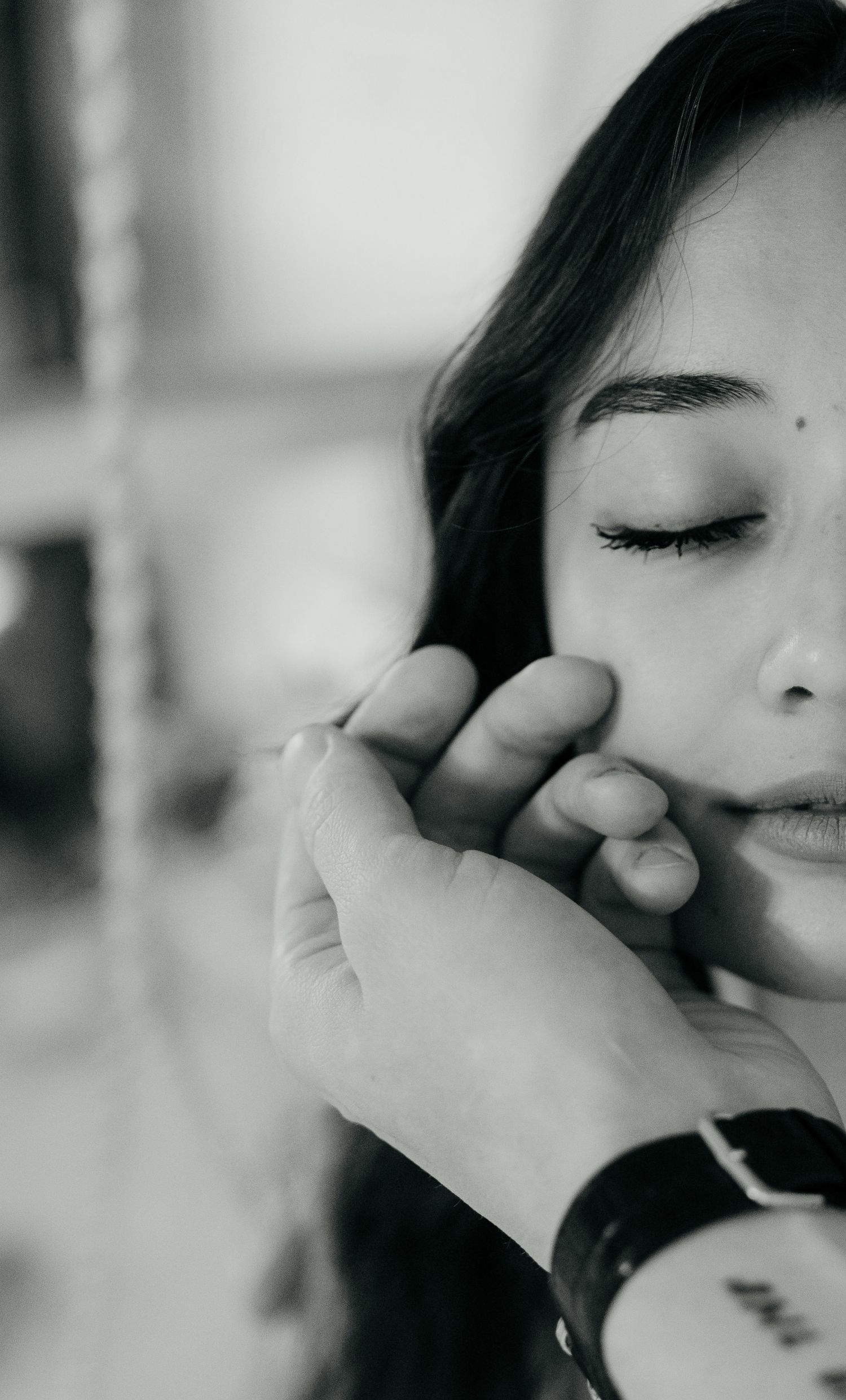 A close-up black and white portrait showing delicate emotional expressions.