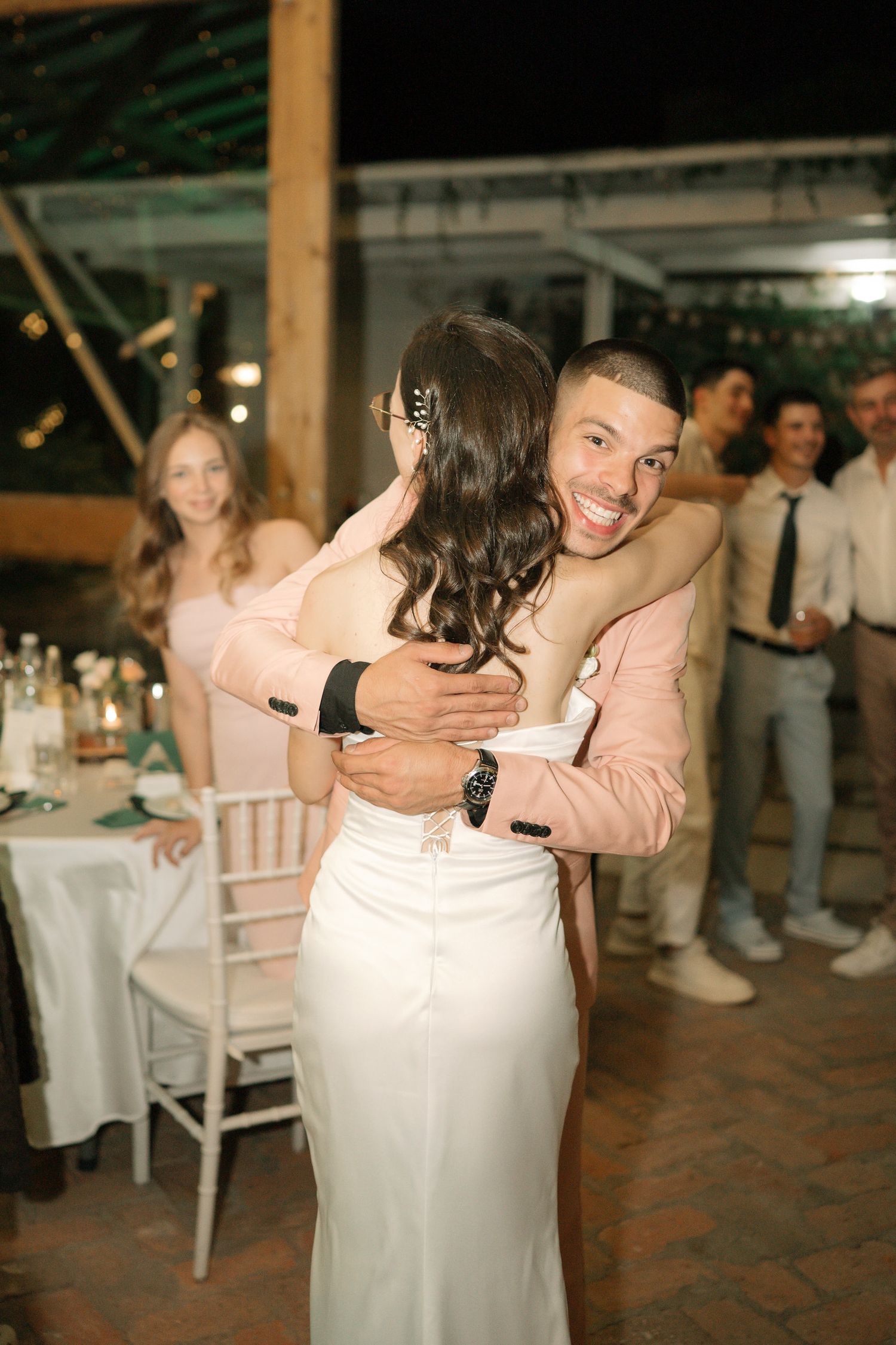A series of candid dance floor moments at a wedding reception showing people embracing and dancing together.