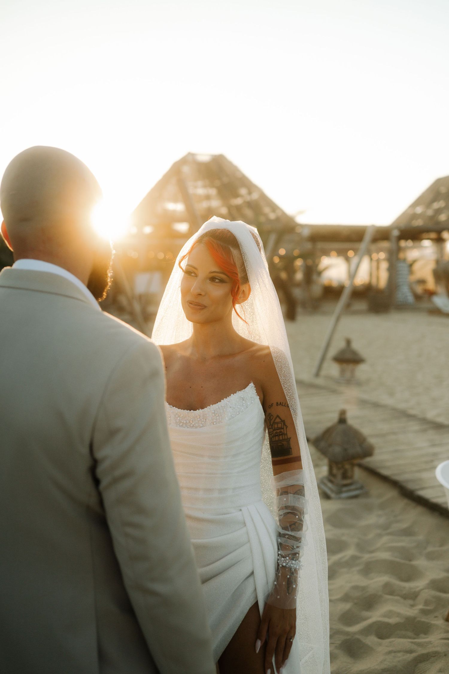 A romantic beach wedding photoshoot with the couple silhouetted against the golden sunset.