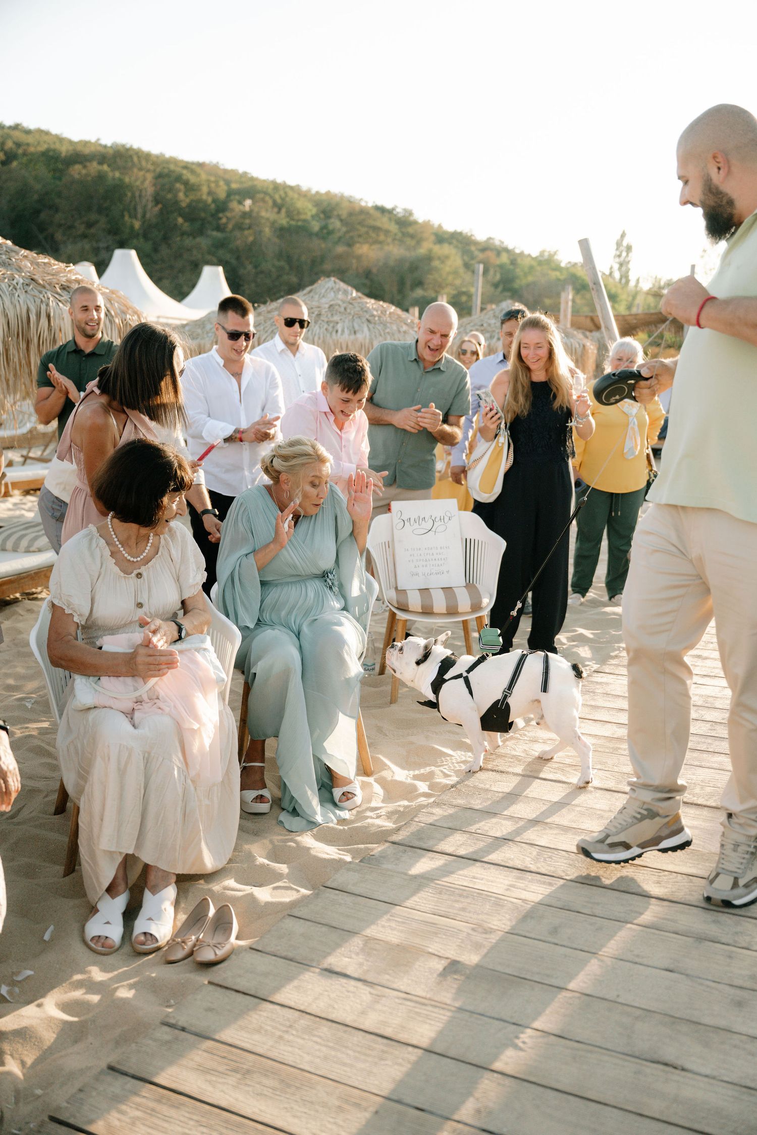 A group of wedding guests dancing and celebrating on an outdoor patio during golden hour.