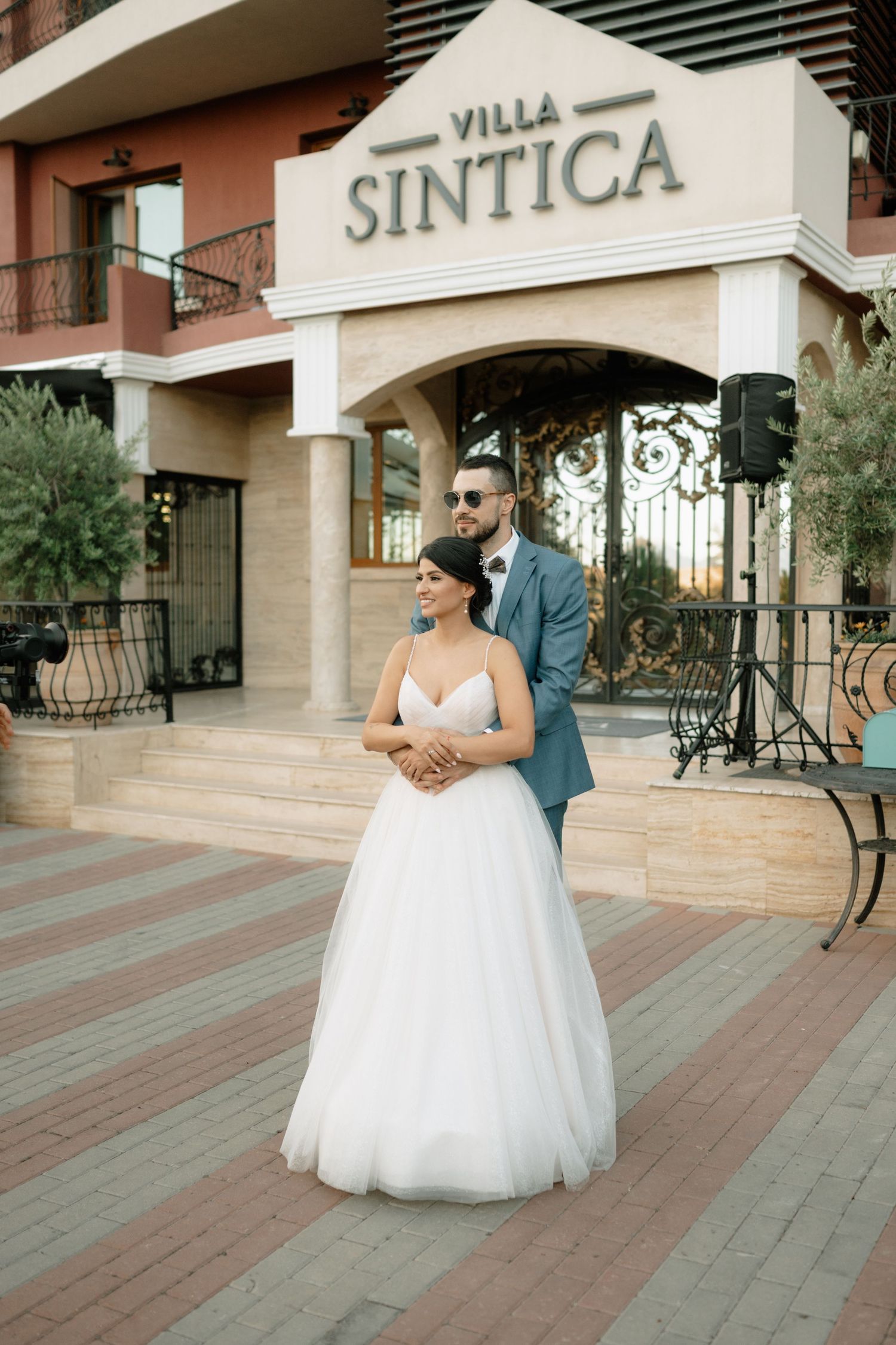 A romantic wedding couple shares an intimate moment on a terrace outside Villa Sintica.