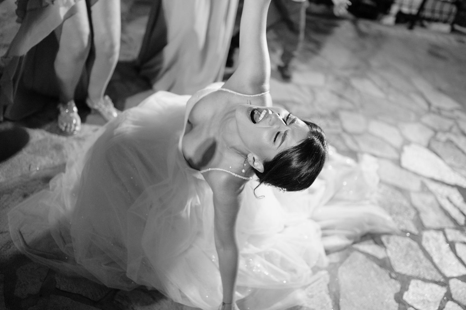 A black and white photo sequence shows a person lying down and rolling across a white surface.