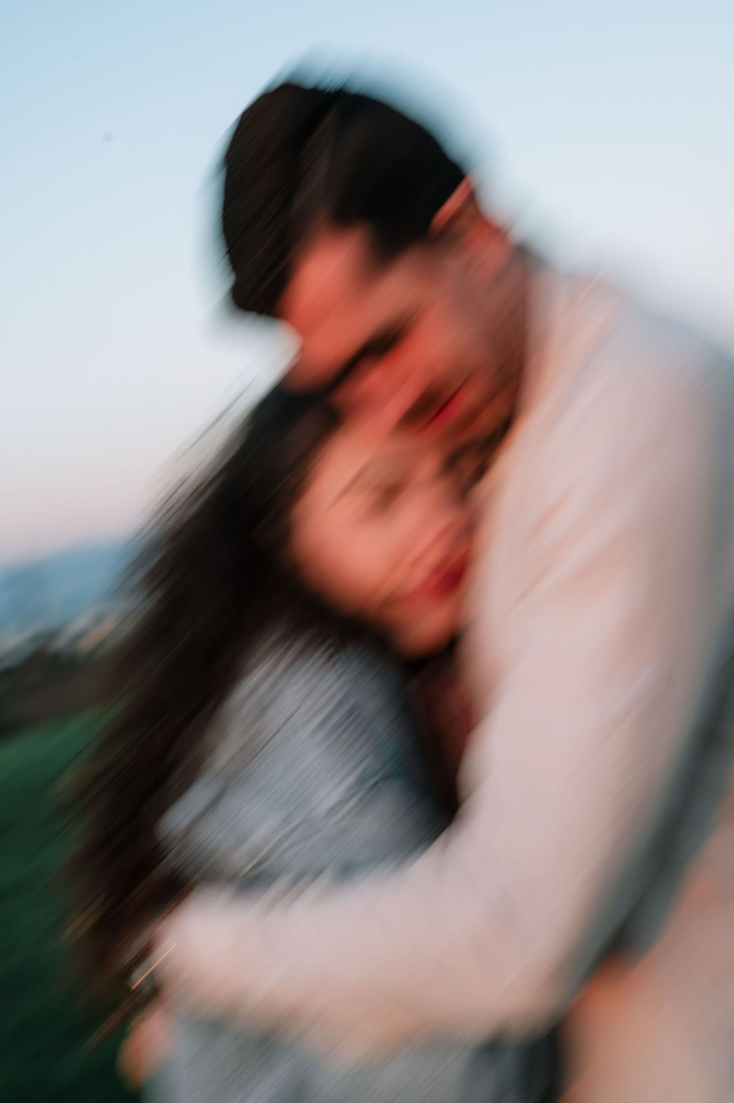 Abstract blurred motion portrait capturing intimate moments at golden hour in nature.