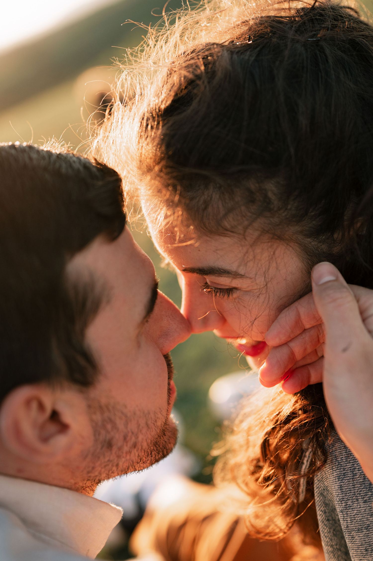 A romantic close-up portrait of a couple sharing an intimate moment in warm sunlight.