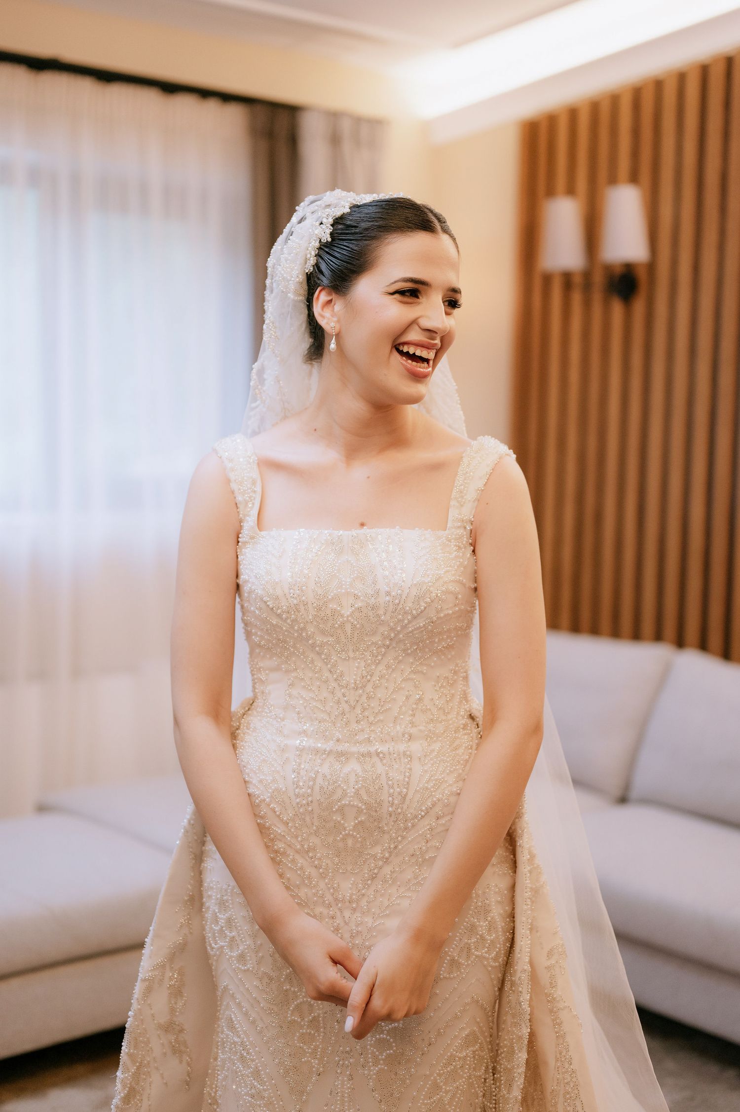 Natural candid shots of a bride wearing an elegant sequined wedding dress with veil.