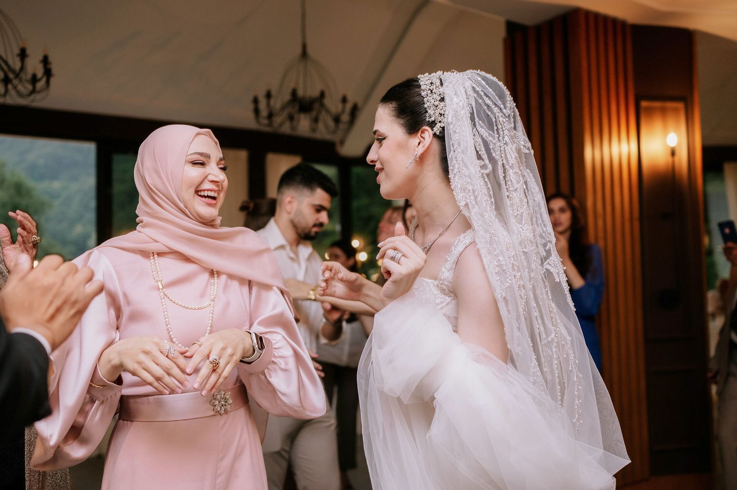 Festive wedding reception with guests dancing and celebrating in an elegant venue.
