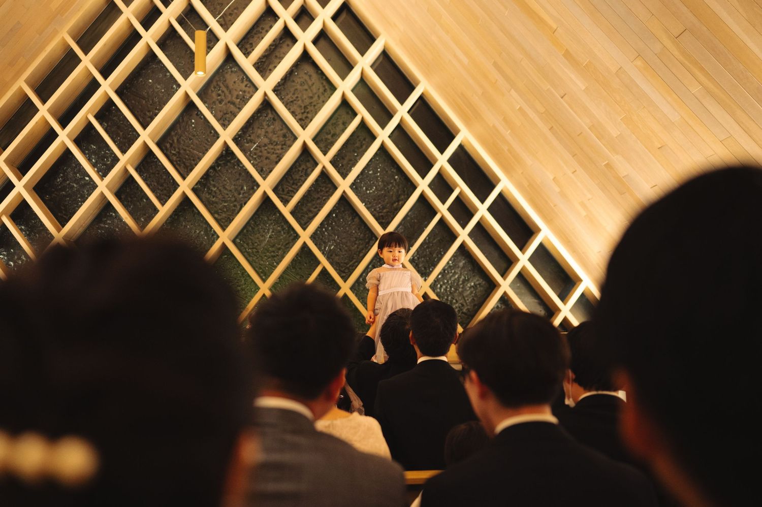 View of geometric wooden lattice wall design from audience perspective.