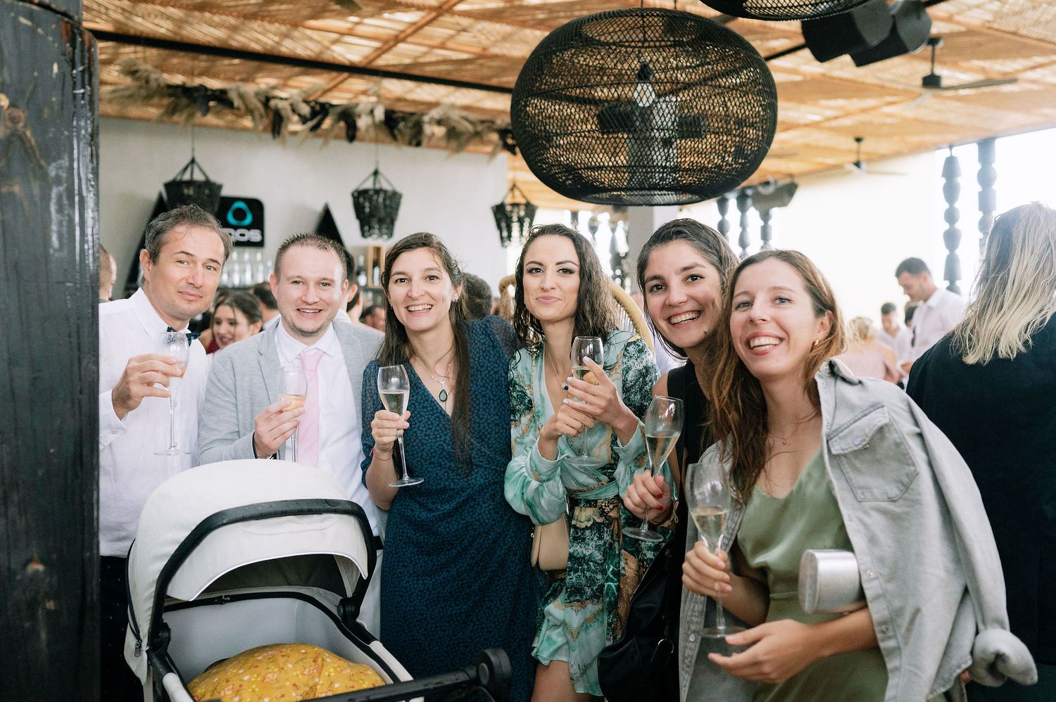 Group of people mingling at a casual indoor event with wooden ceiling.