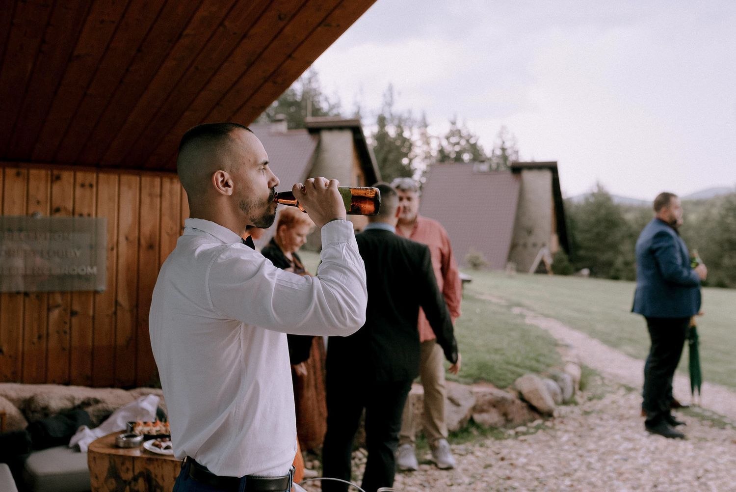 Wedding celebration inside rustic wooden pavilion with natural lighting.