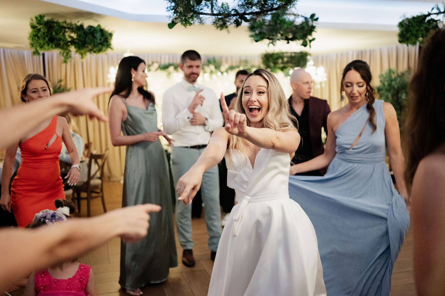 Wedding party guests dancing and celebrating together at a lively reception party.