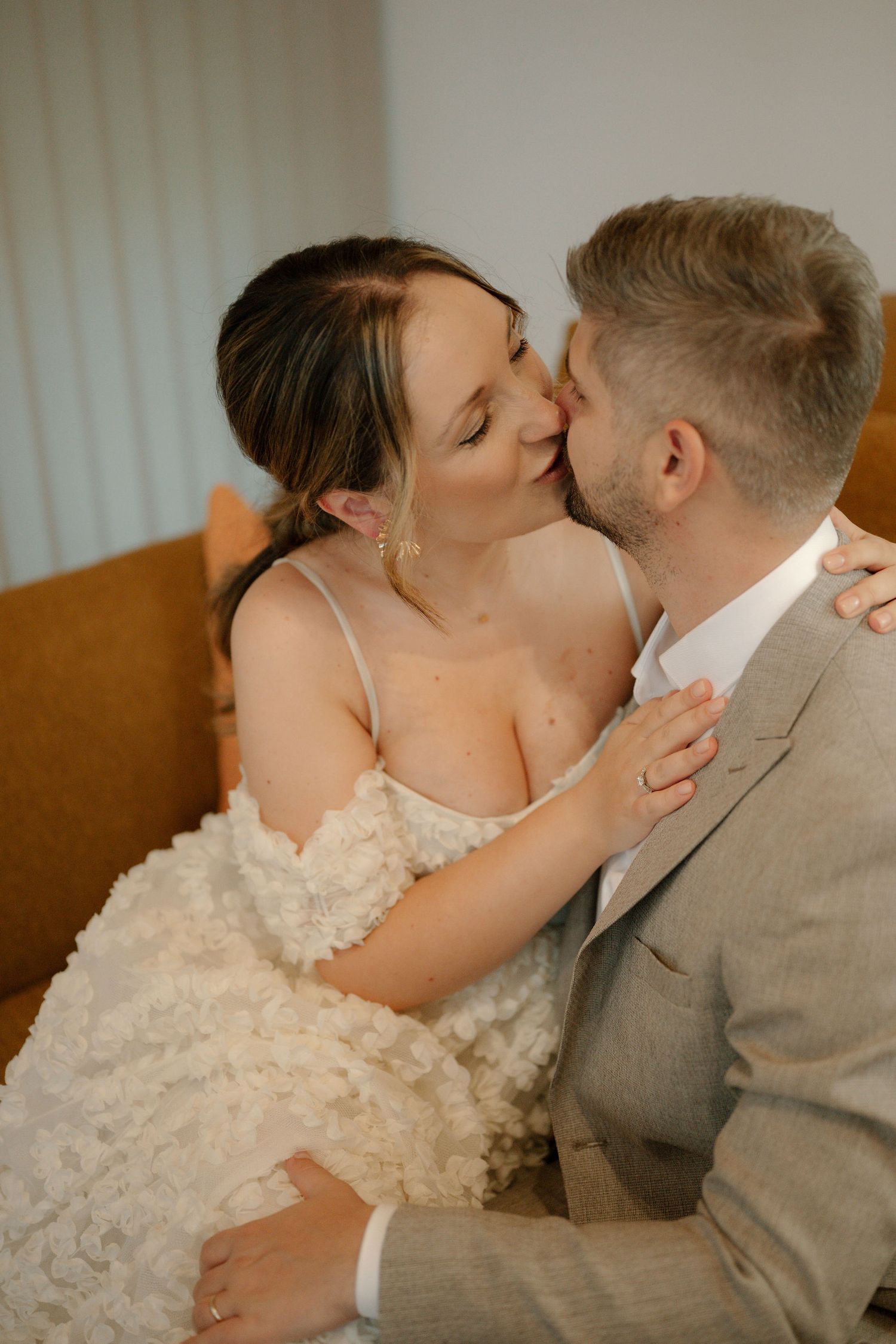 A romantic wedding moment captured in a series of intimate kisses between a couple, with the bride in a textured dress.