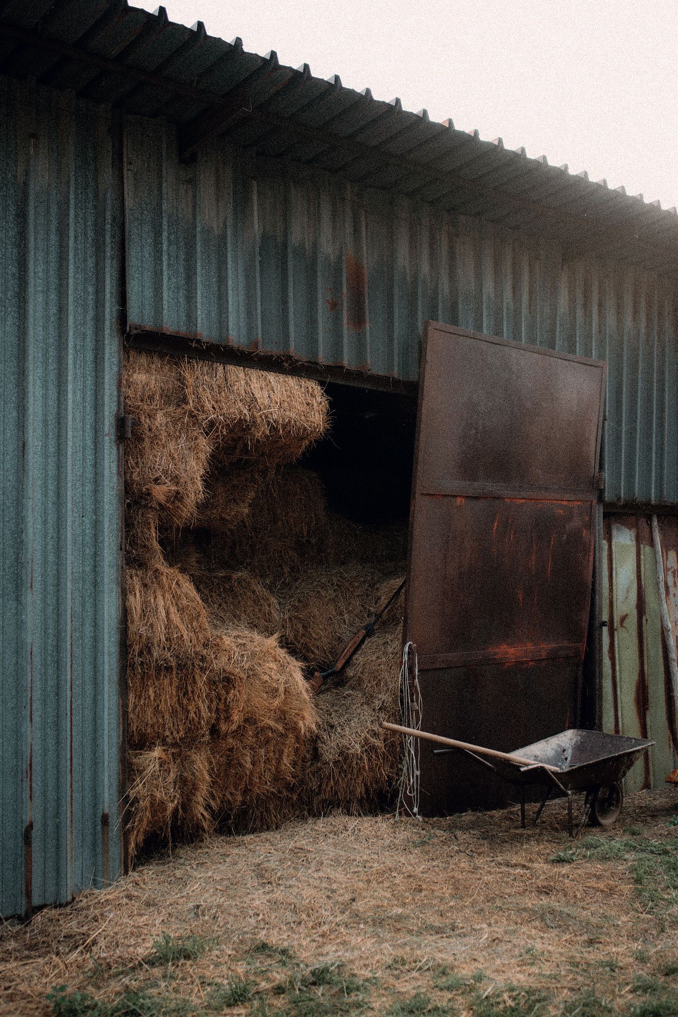 Progressive sequence showing hay bales falling and spilling out of a metal storage shed door over time.