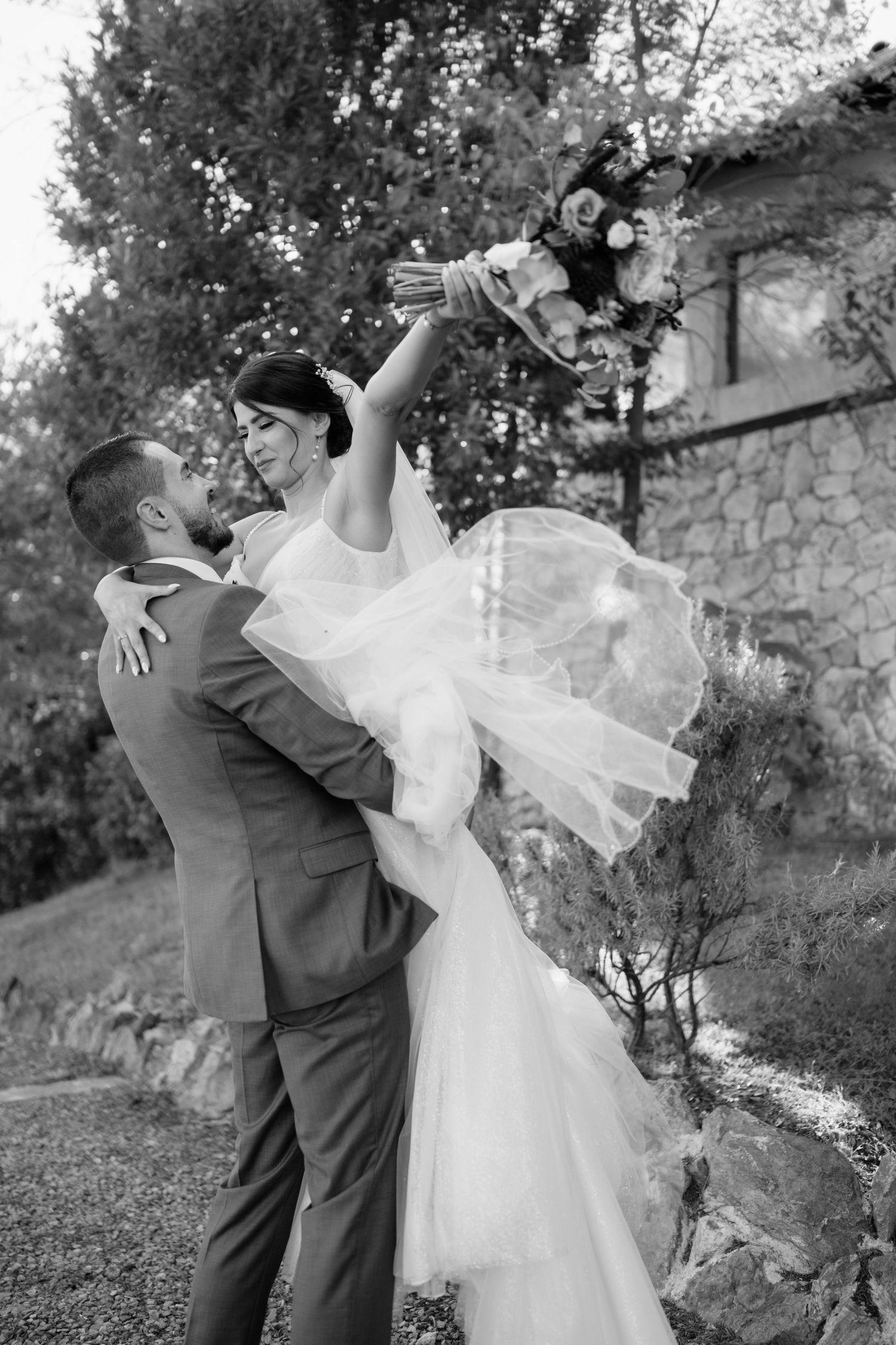 A romantic black and white wedding sequence shows a couple dancing and twirling in an outdoor garden setting.