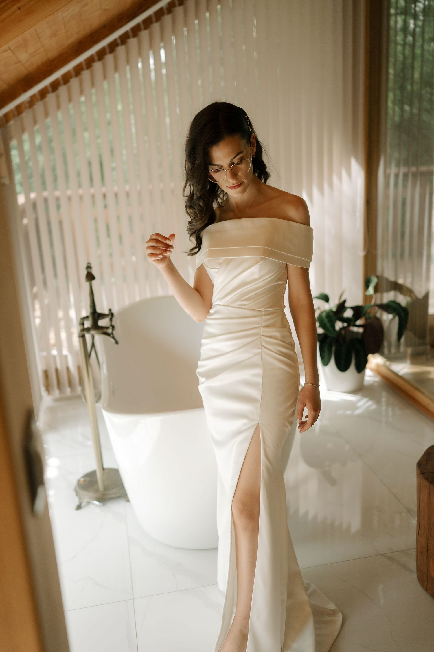 Multiple views of an elegant white wedding dress with a thigh slit being showcased in a bright indoor setting.