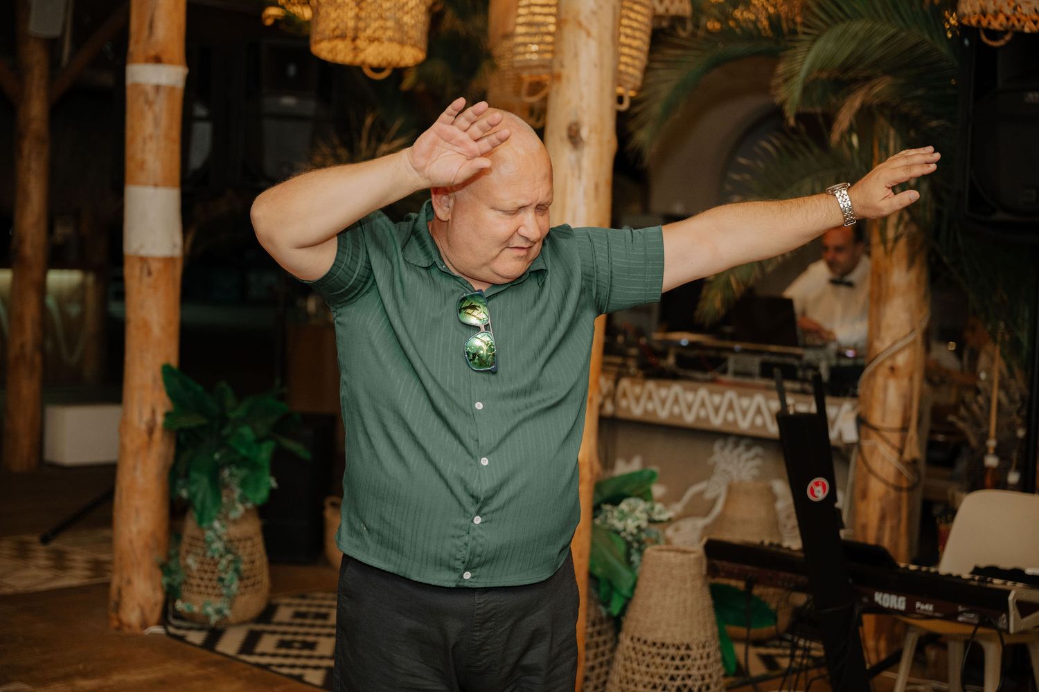 People dancing and enjoying themselves at an indoor wedding reception with wooden decor and warm lighting.