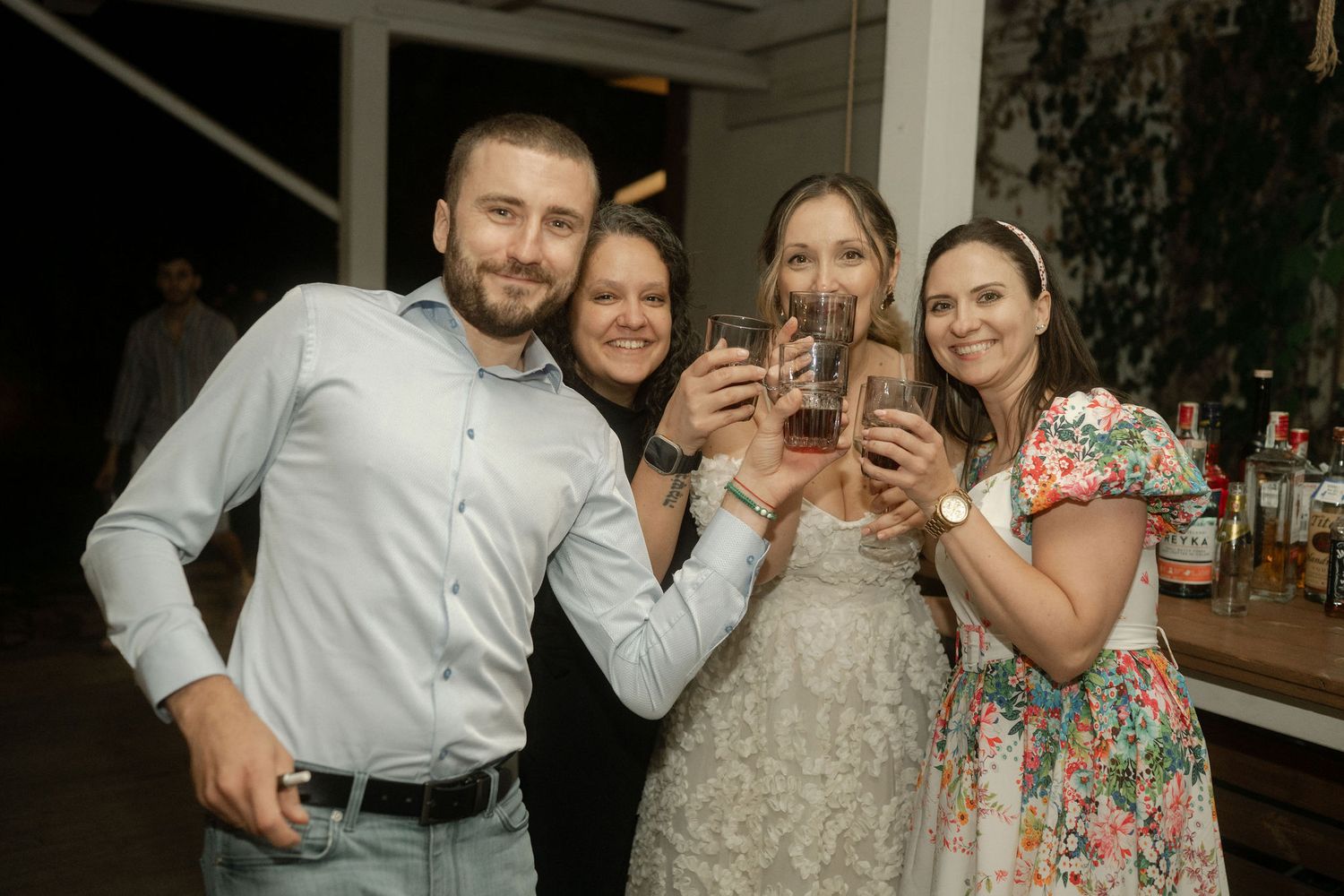Wedding guests dance and celebrate together on a dance floor during an evening reception.