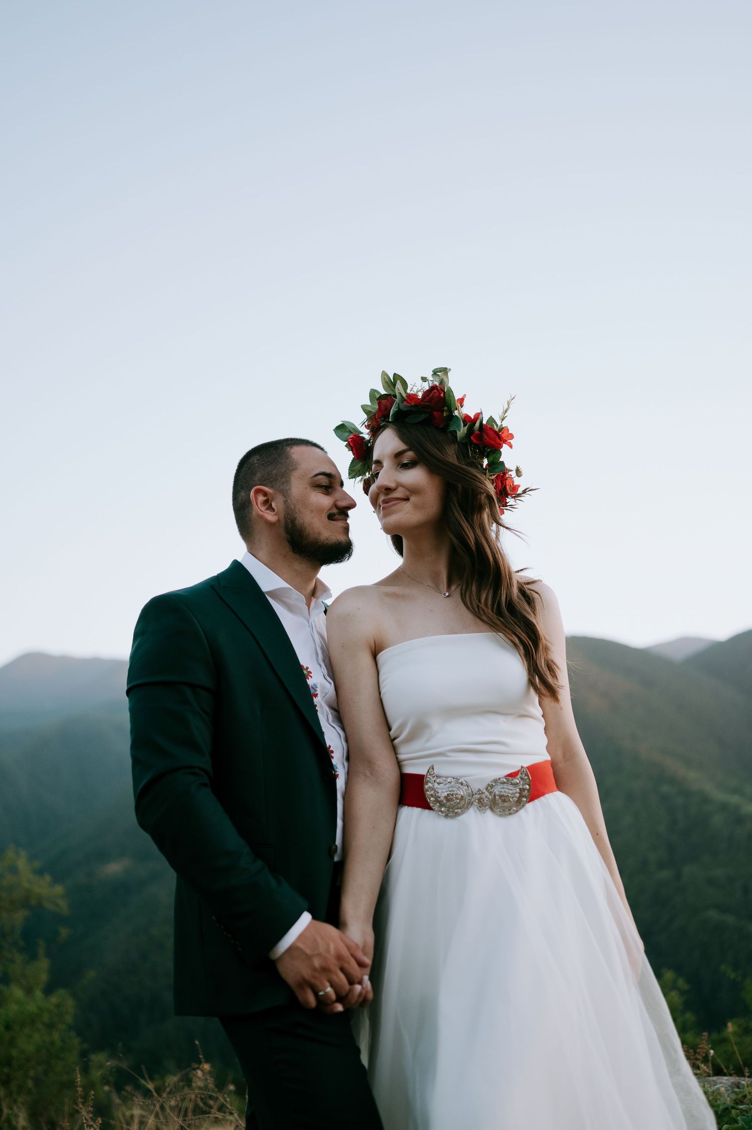 Intimate moment between newlyweds with mountains in background at sunset.