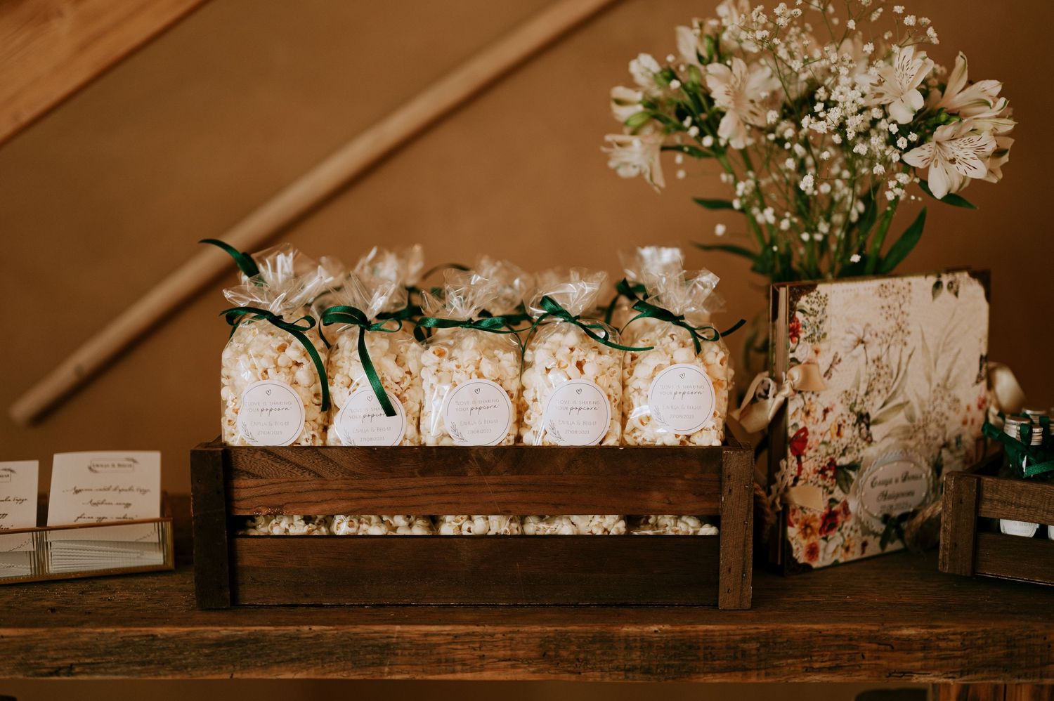 Decorative wooden boxes with white floral arrangements and greenery on rustic shelf.