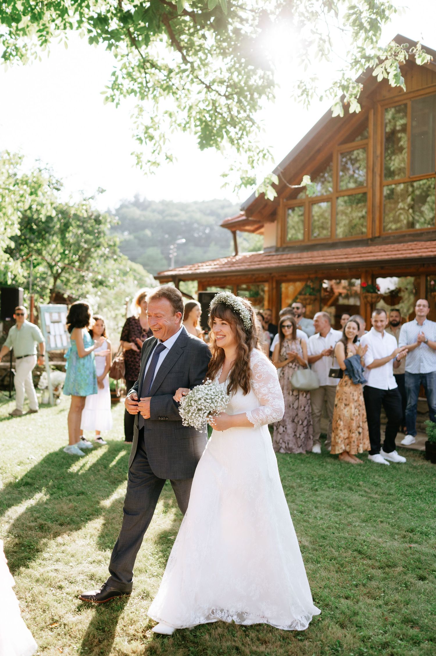 Couple dancing on grass during their outdoor wedding reception at a rustic lodge.