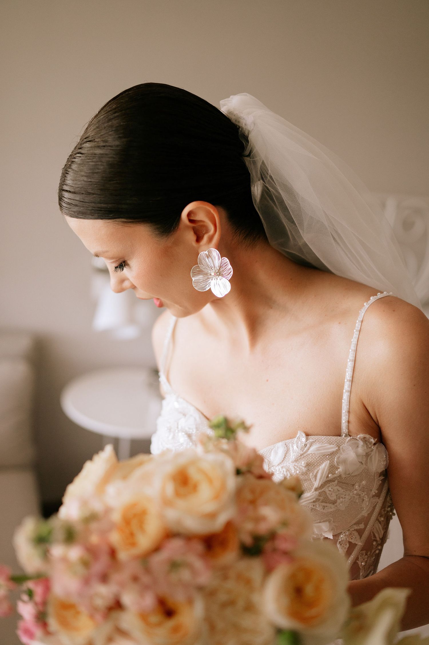 Close-up detail of bridal accessories and delicate floral bouquet in natural light.