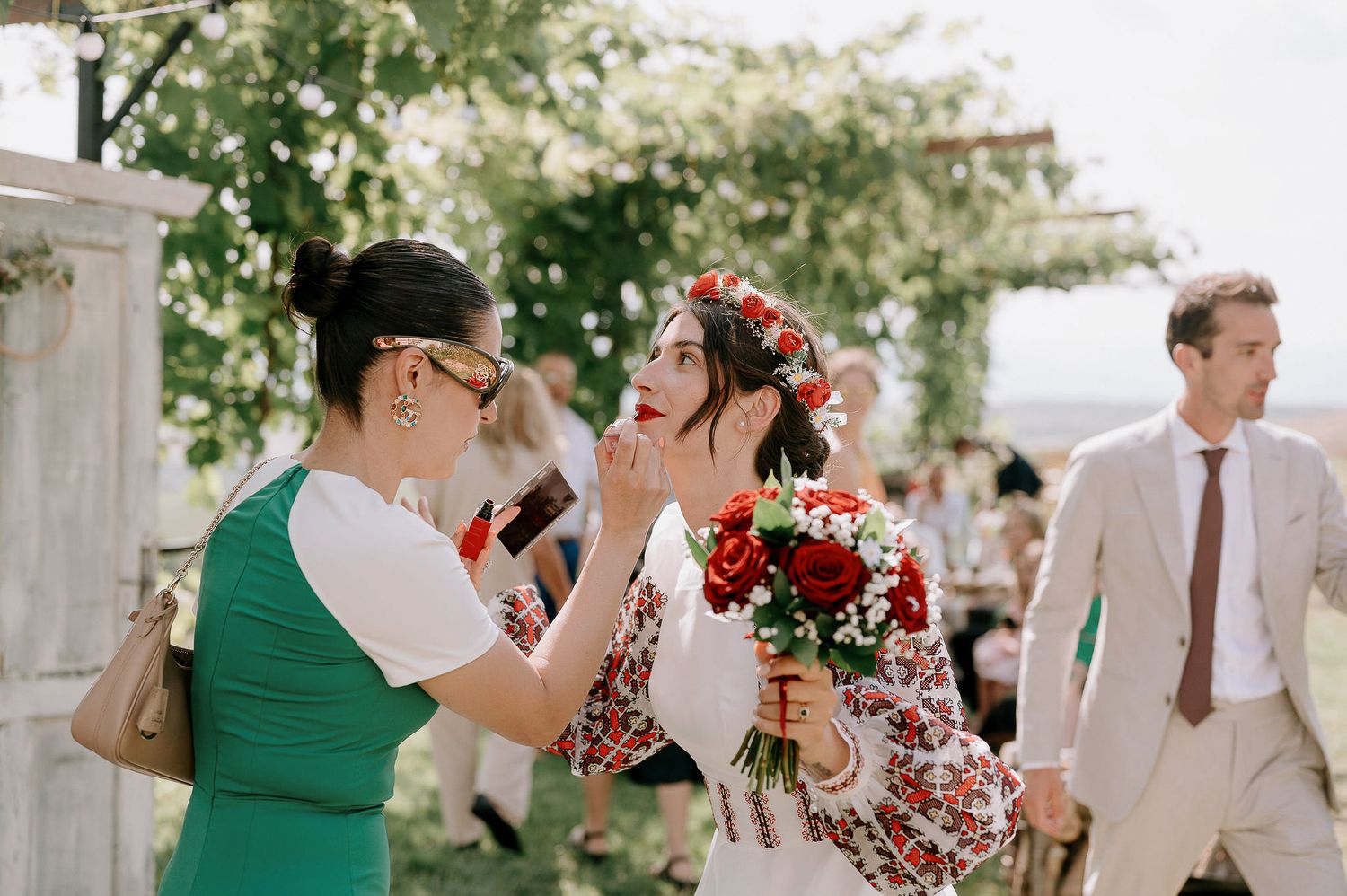 Guests celebrate during an outdoor garden wedding with vibrant floral arrangements.