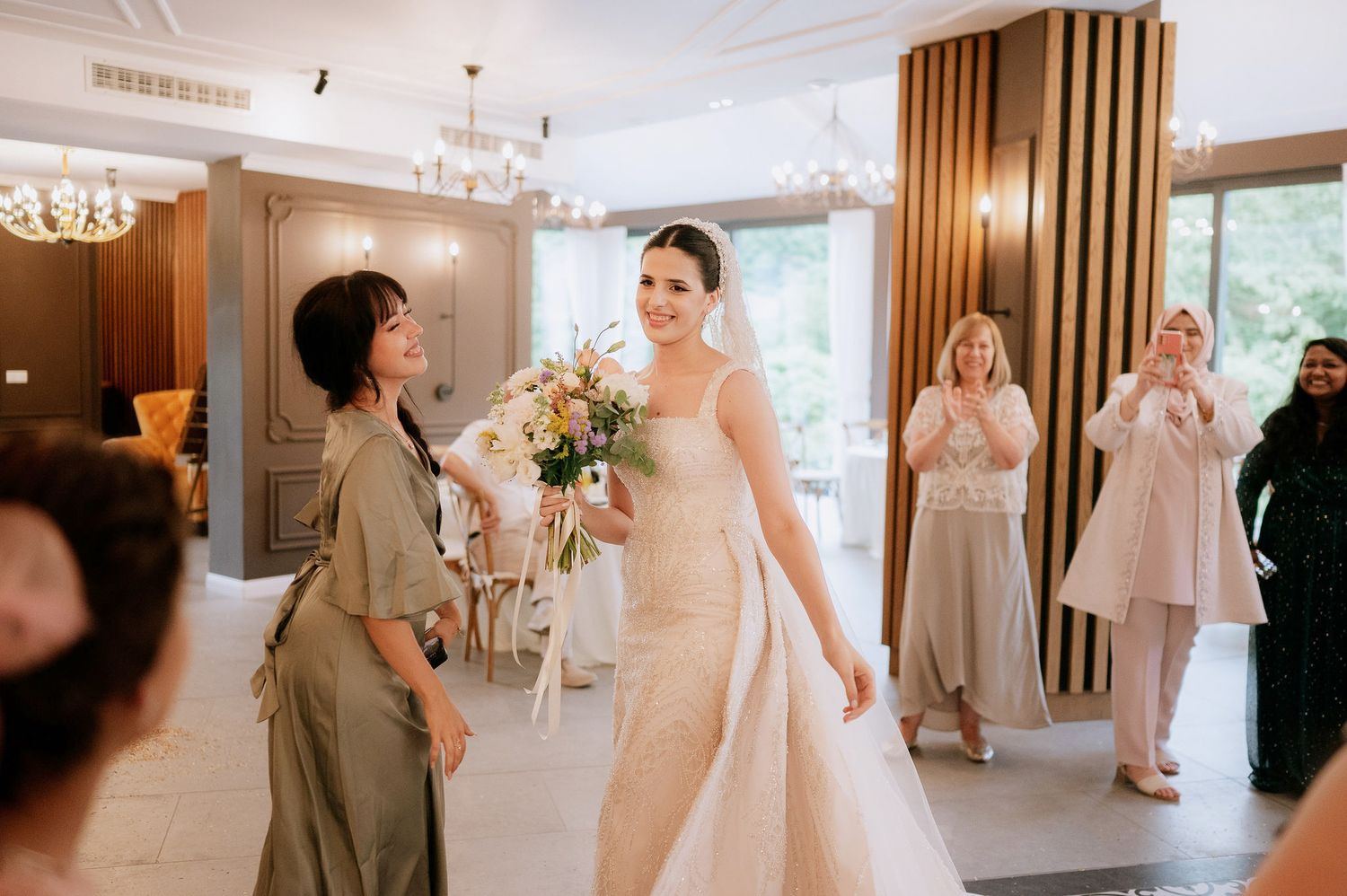 Wedding celebration in an elegant indoor venue with modern lighting and wood accents.