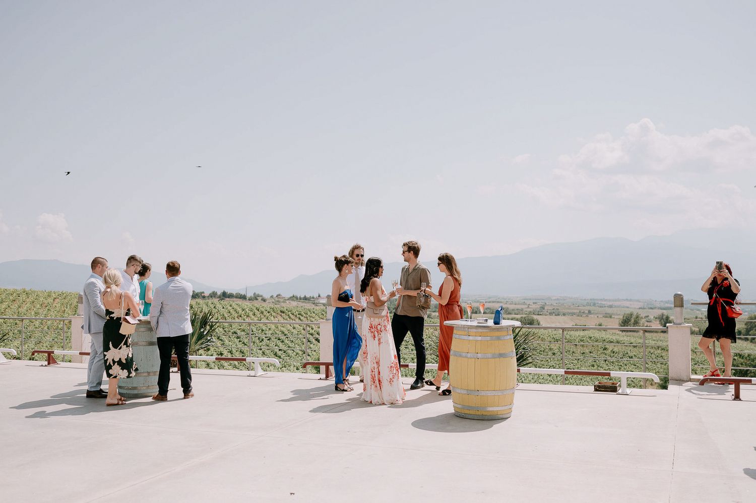 A panoramic view of people gathering at an outdoor desert venue with mountains in the background.