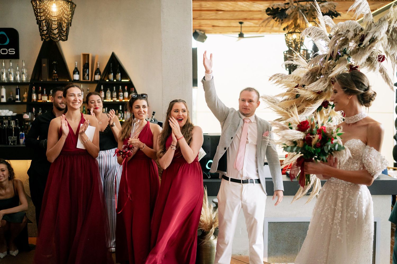 Wedding reception venue decorated with warm lighting and elegant floral arrangements.