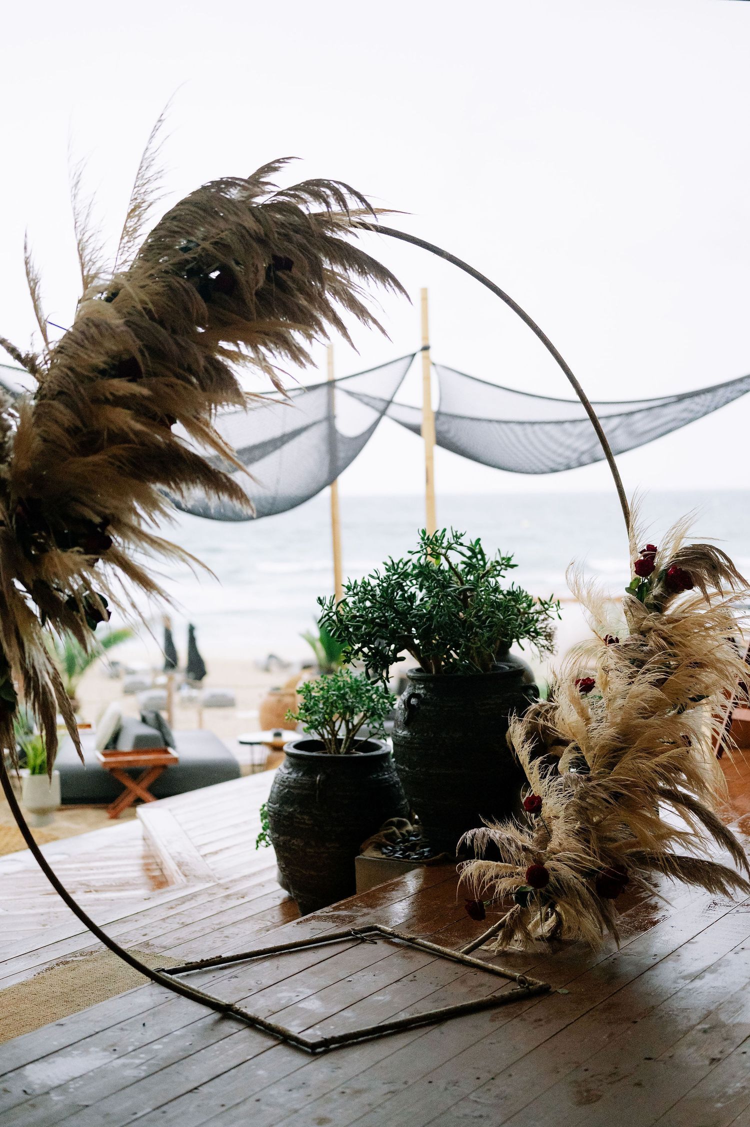 Decorative dried pampas grass arrangements with fabric draping in event space.
