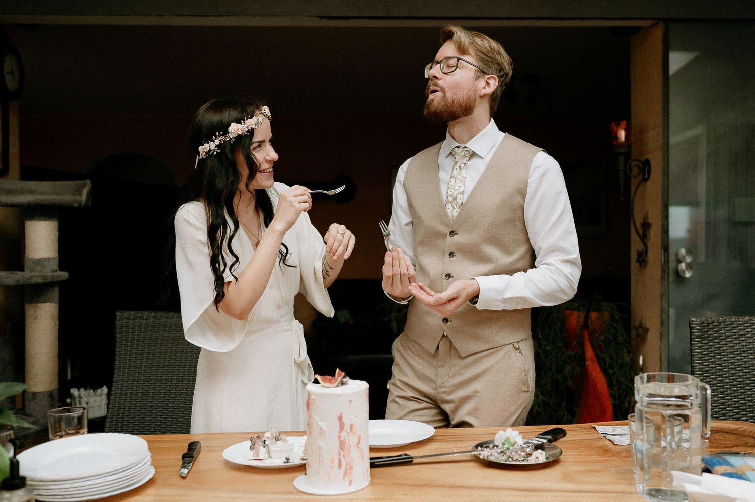 Couple enjoying their intimate wedding celebration with a small decorated cake.