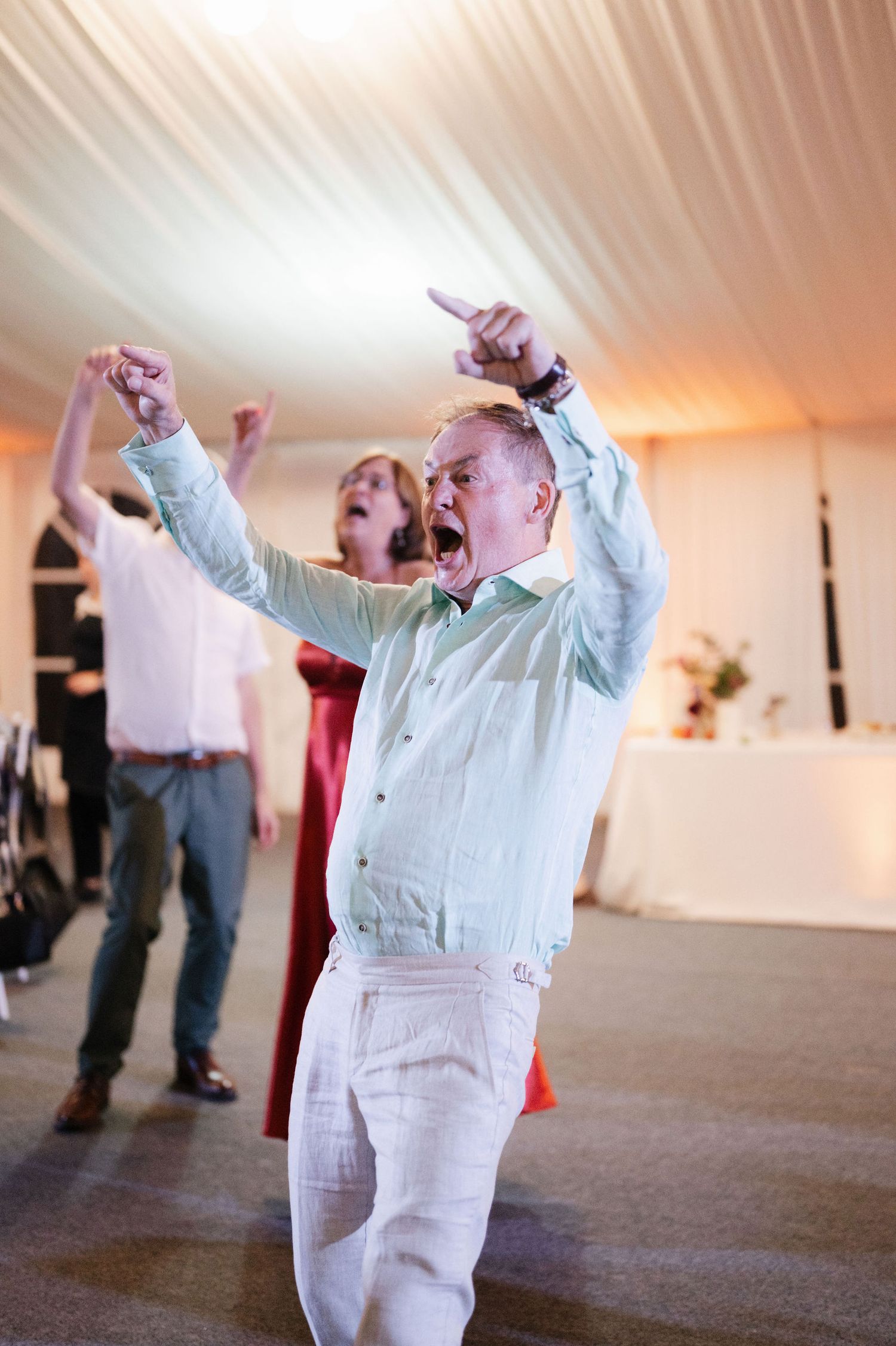 A series of photos showing people practicing tai chi exercises with raised arms in a bright indoor space.