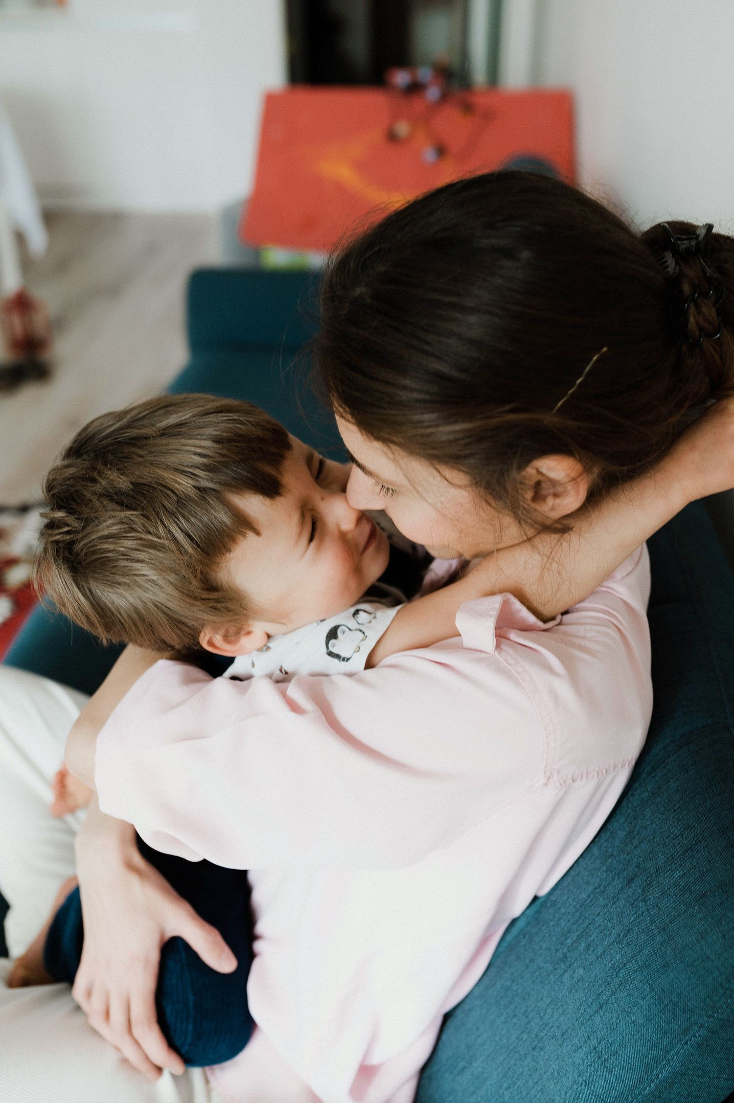 A series of tender moments captured in four sequential photos showing an intimate embrace on a dark blue couch.