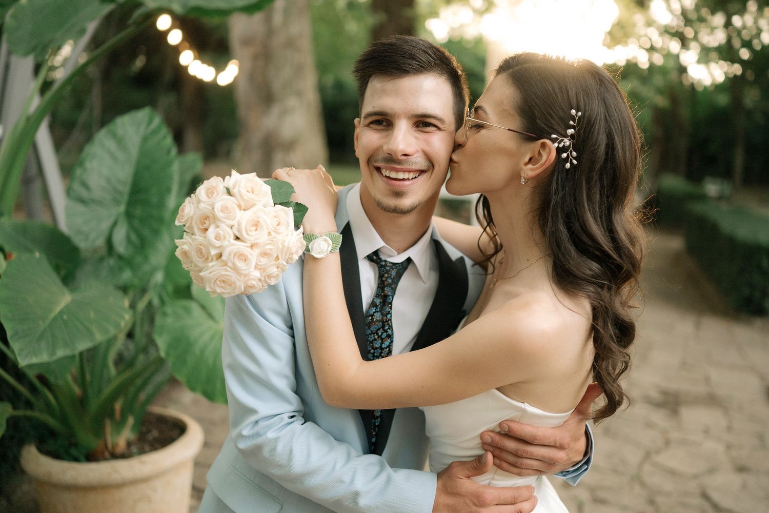 Romantic couple sharing tender moments in a lush garden setting during a wedding celebration.