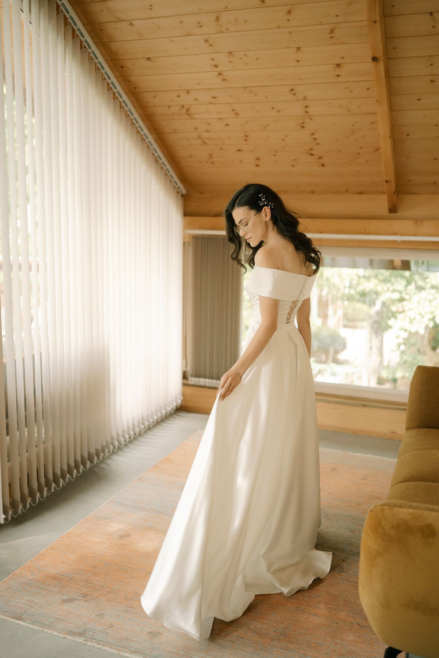 A bride in a flowing white wedding dress twirls gracefully in a rustic wooden porch setting.