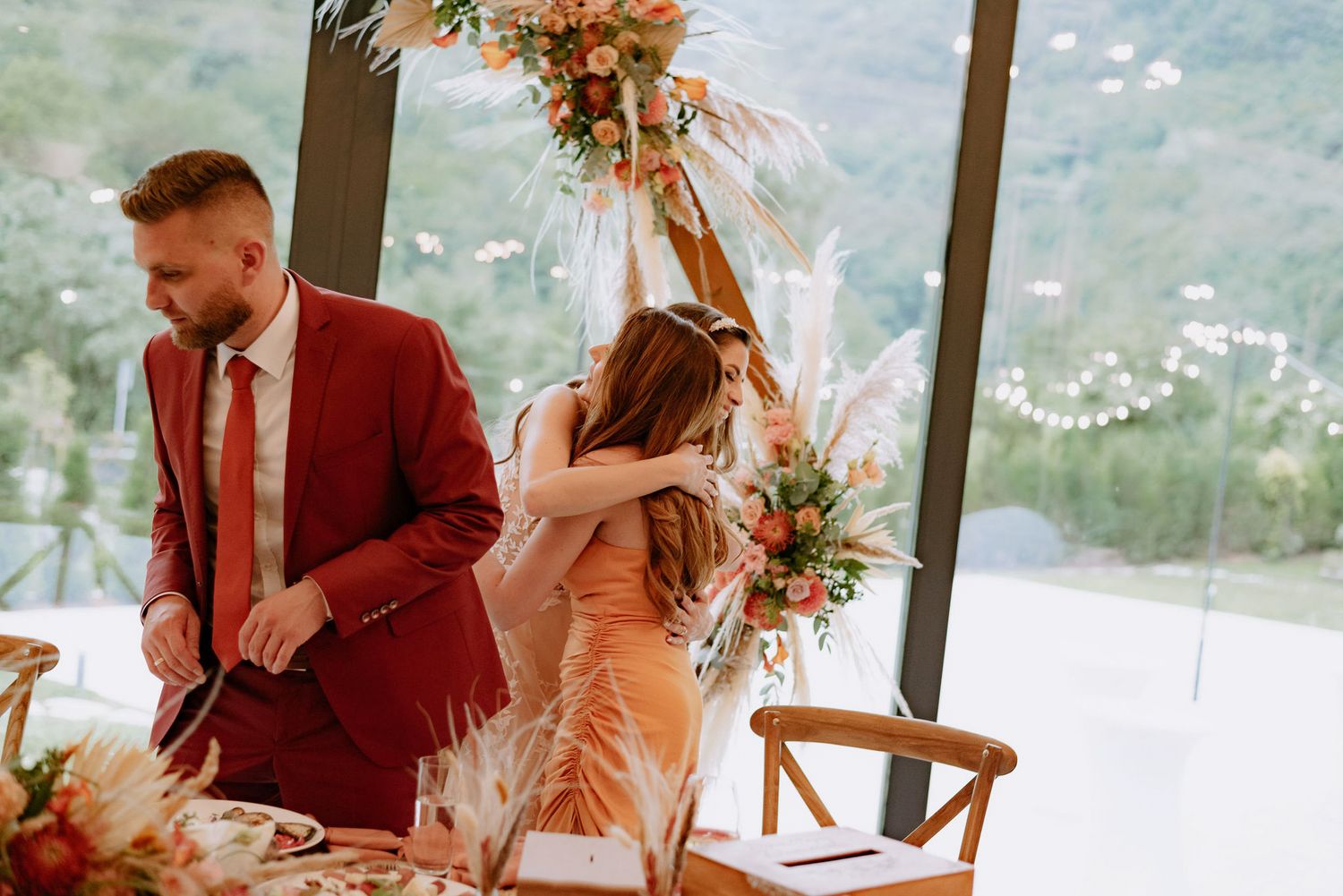Couple in burgundy and white wedding attire share intimate moments during their mountain view ceremony.