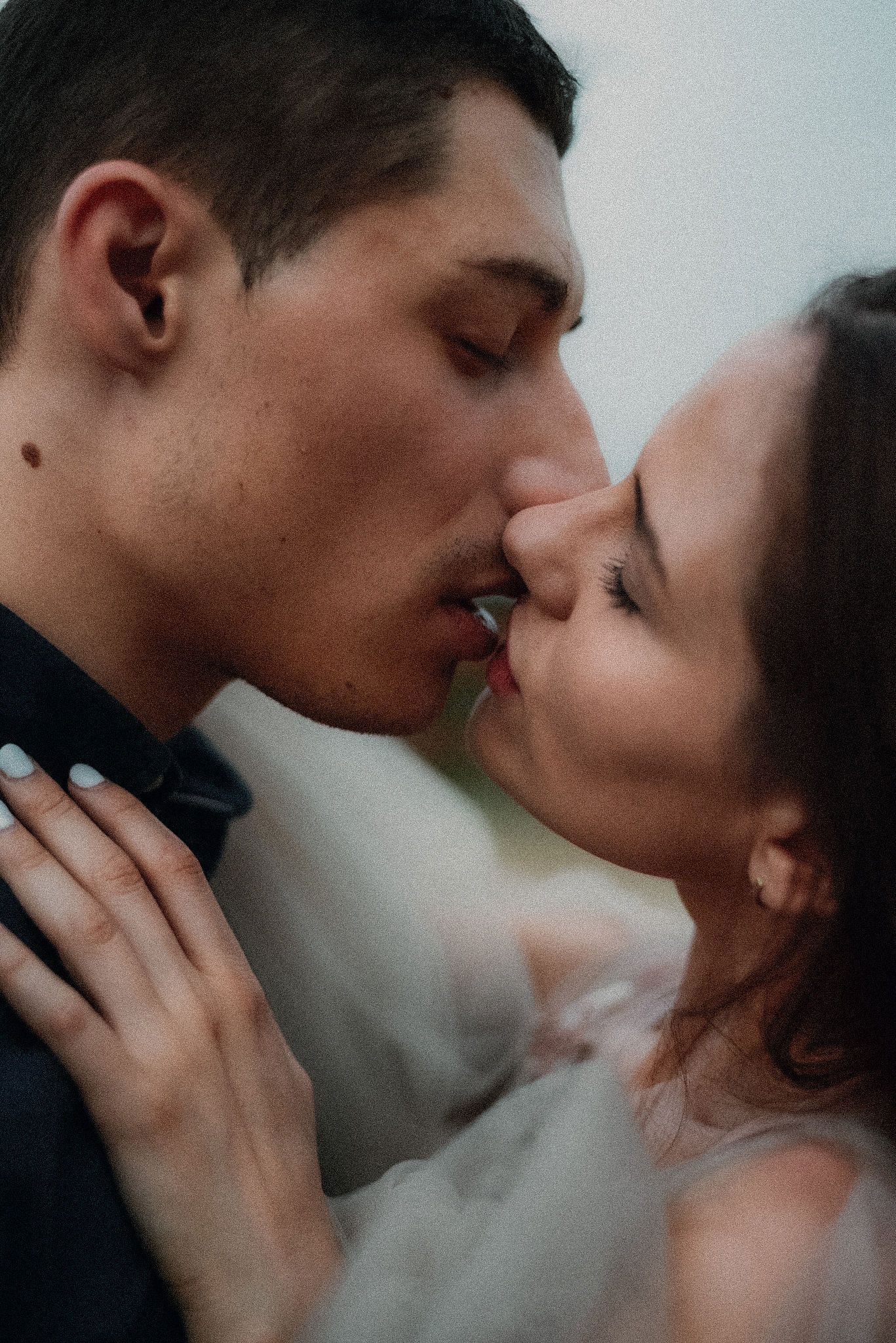Intimate close-up portrait of a couple sharing a tender romantic moment in soft lighting.