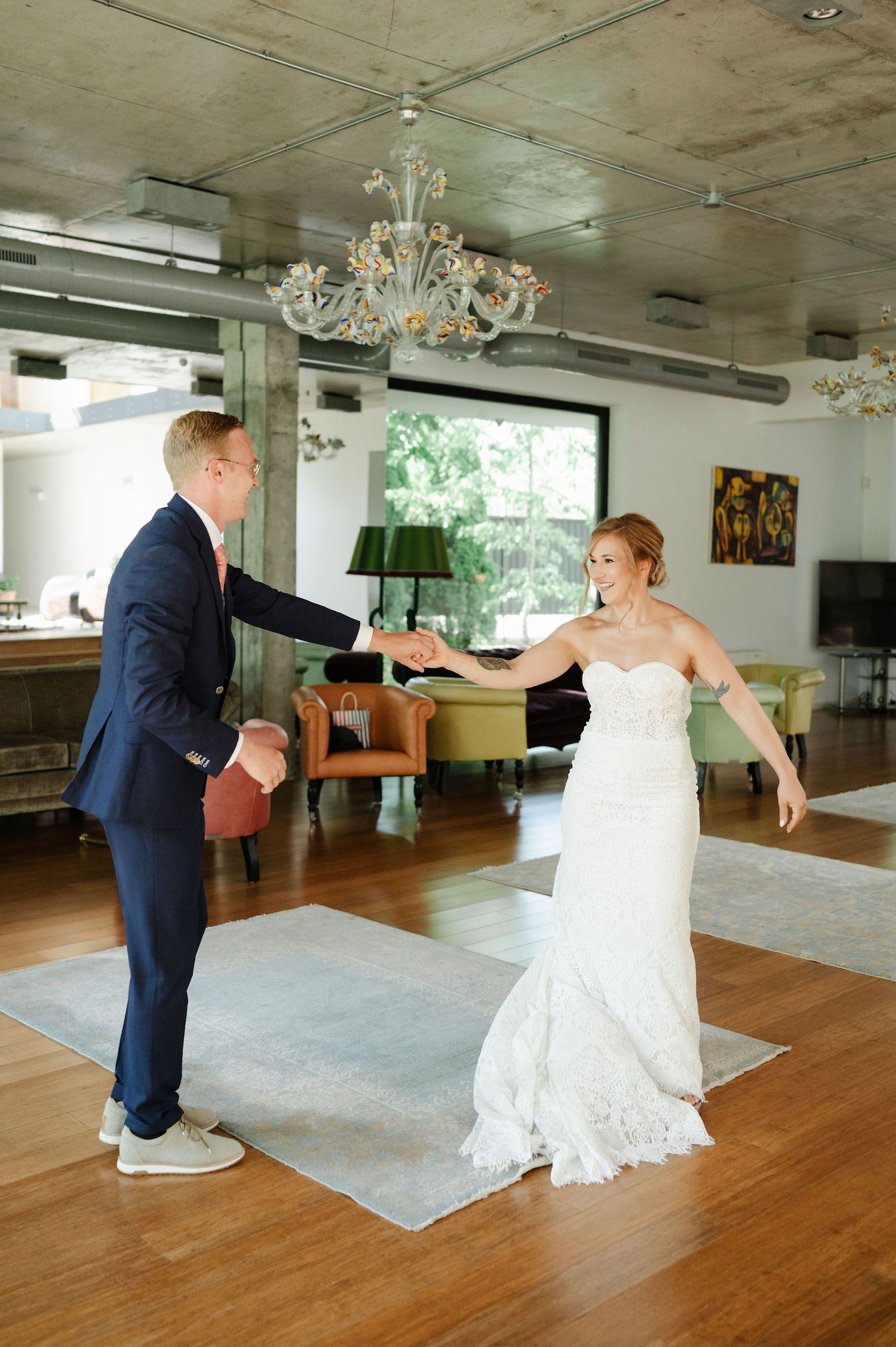 Wedding couple performing playful dance moves in a modern reception venue.