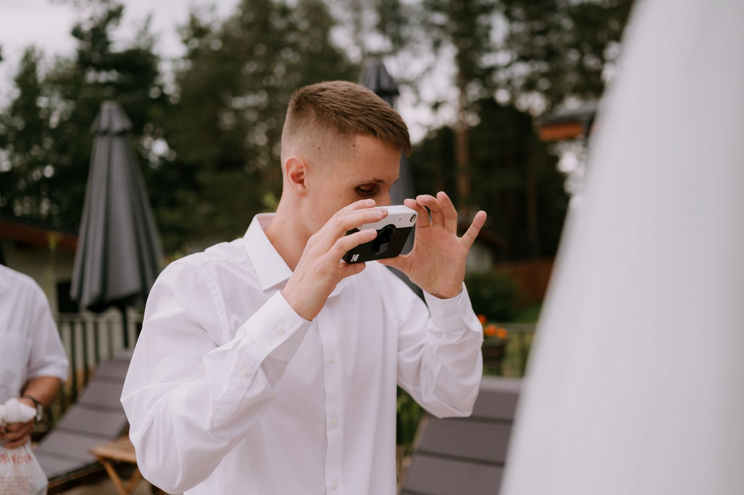 Outdoor wedding celebration with white decor and natural scenery in the background.
