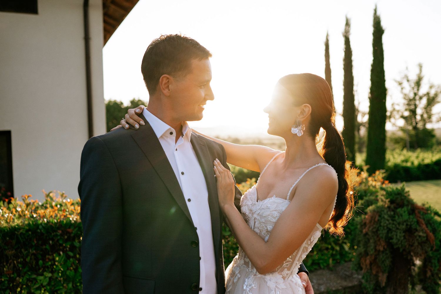 Sunset wedding portraits showing tender moments between newlyweds in a garden setting.
