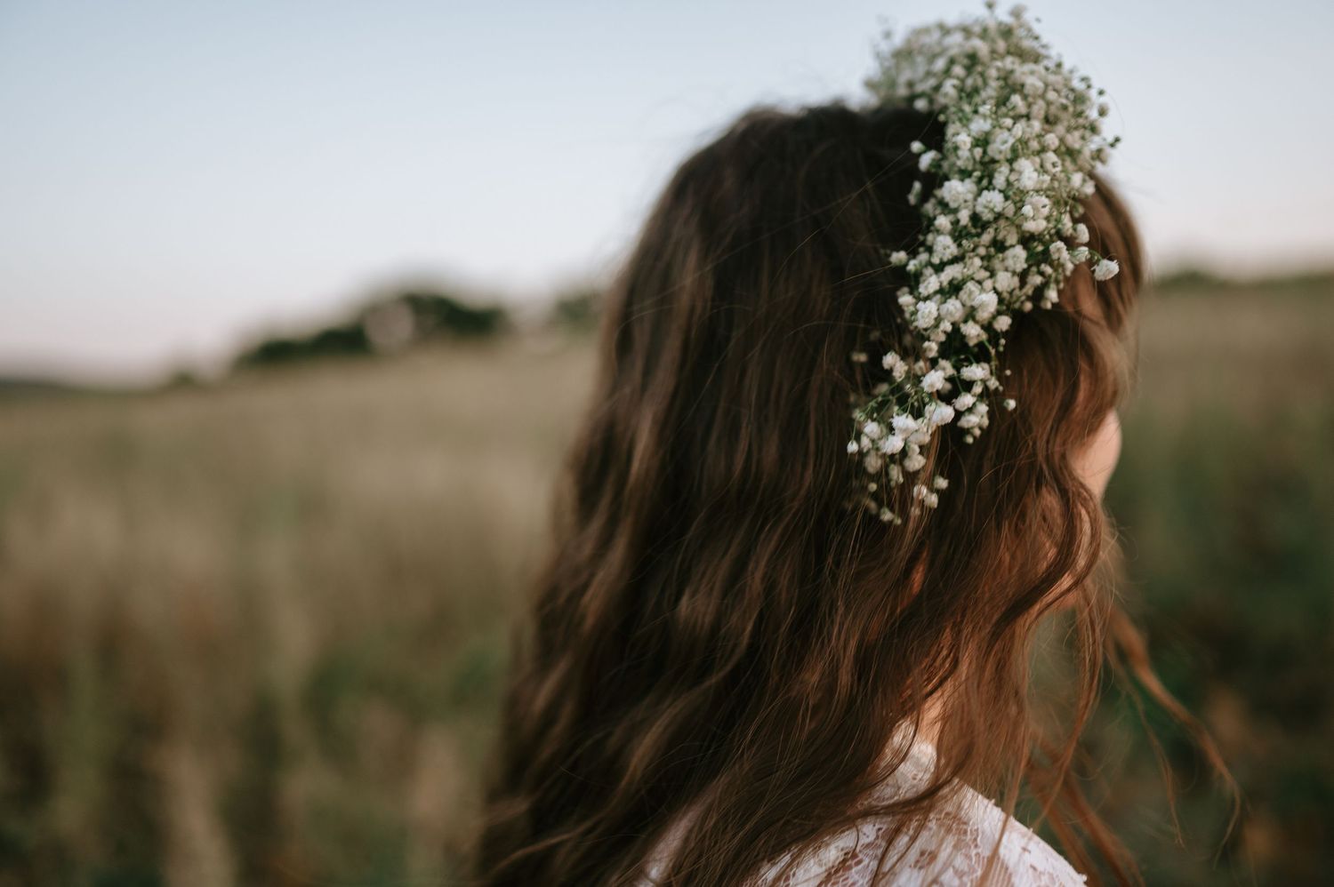 Close-up of baby's breath flower crown against flowing brown hair.