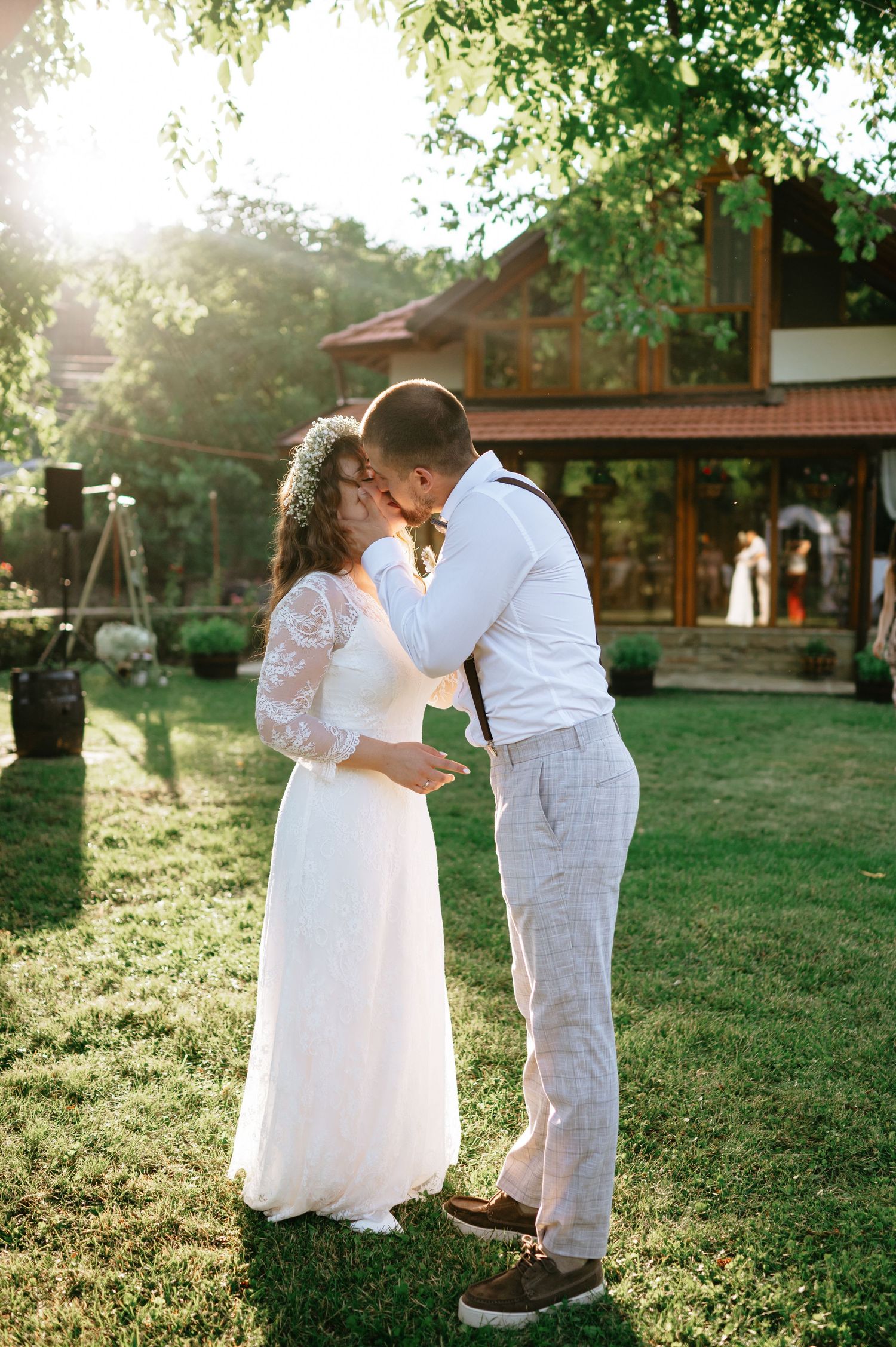 Newlyweds sharing an intimate moment in a sunlit garden setting.