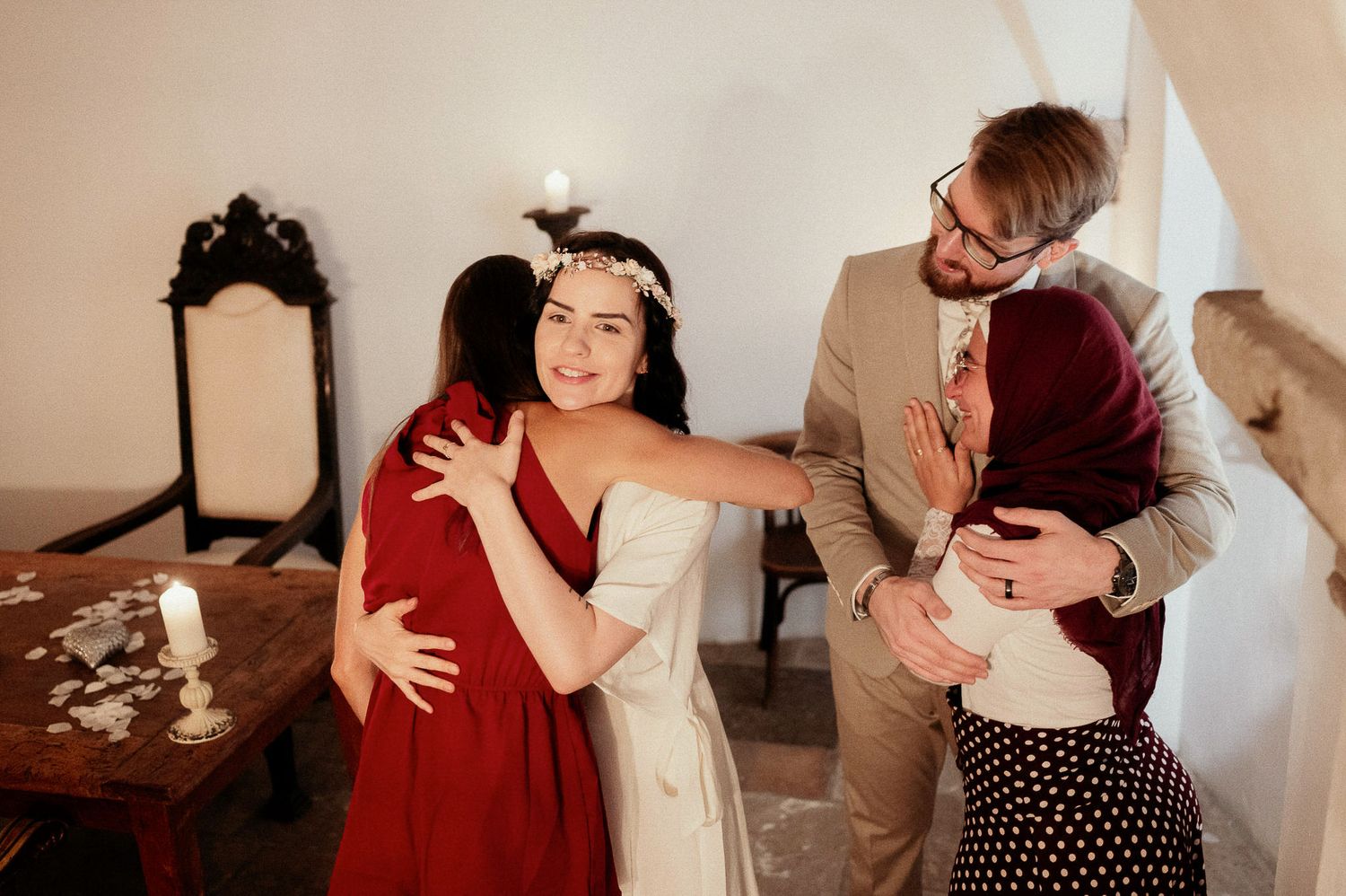 Wedding guests sharing embraces and celebrations in a warmly lit rustic venue.