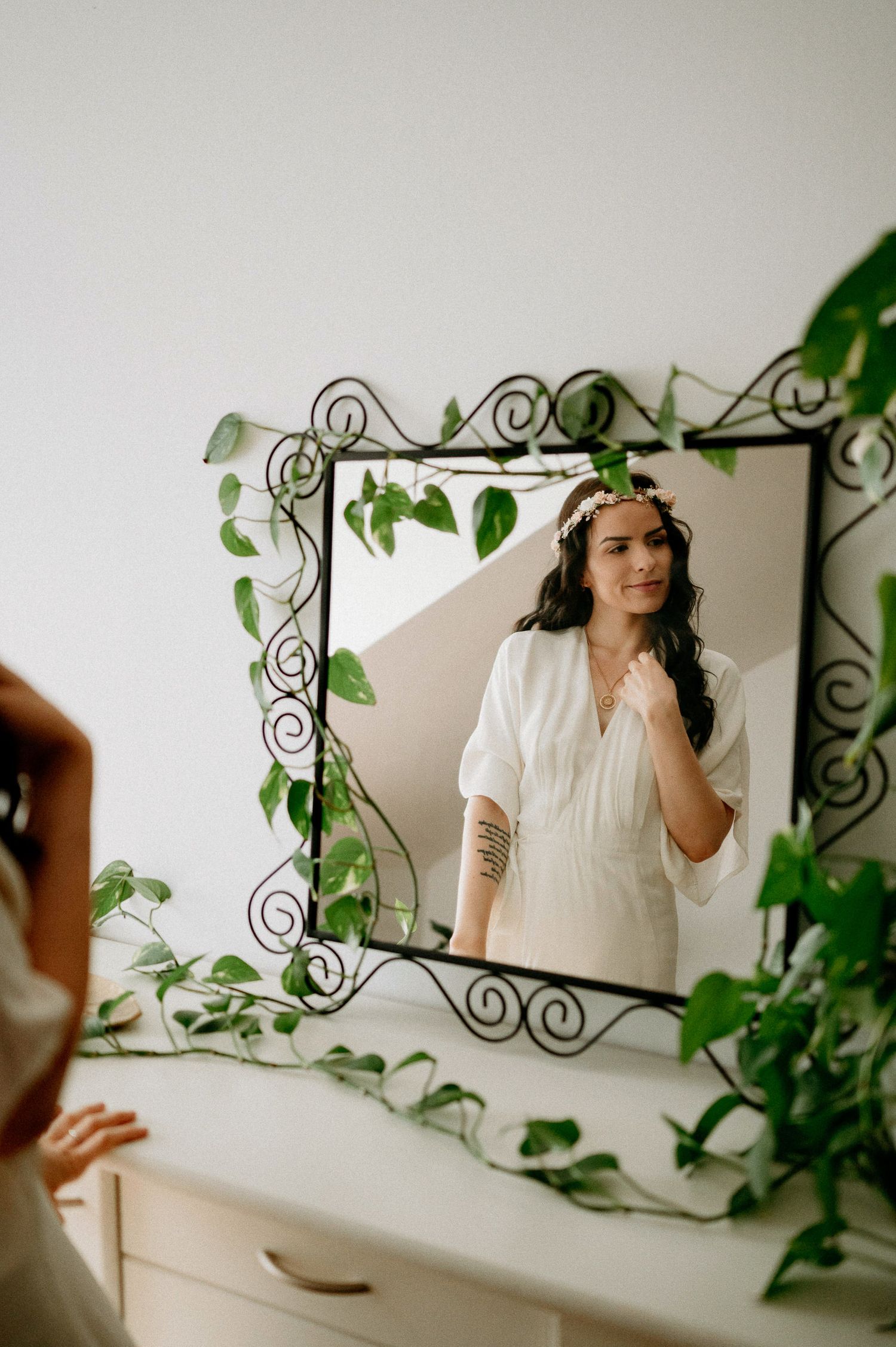 Dreamy portrait with ornate mirror and climbing vines creating ethereal atmosphere.