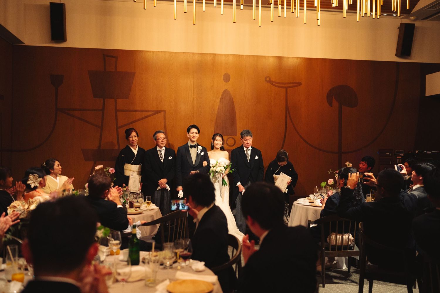 Panoramic view of formal dinner event with guests seated in dimly lit ballroom.