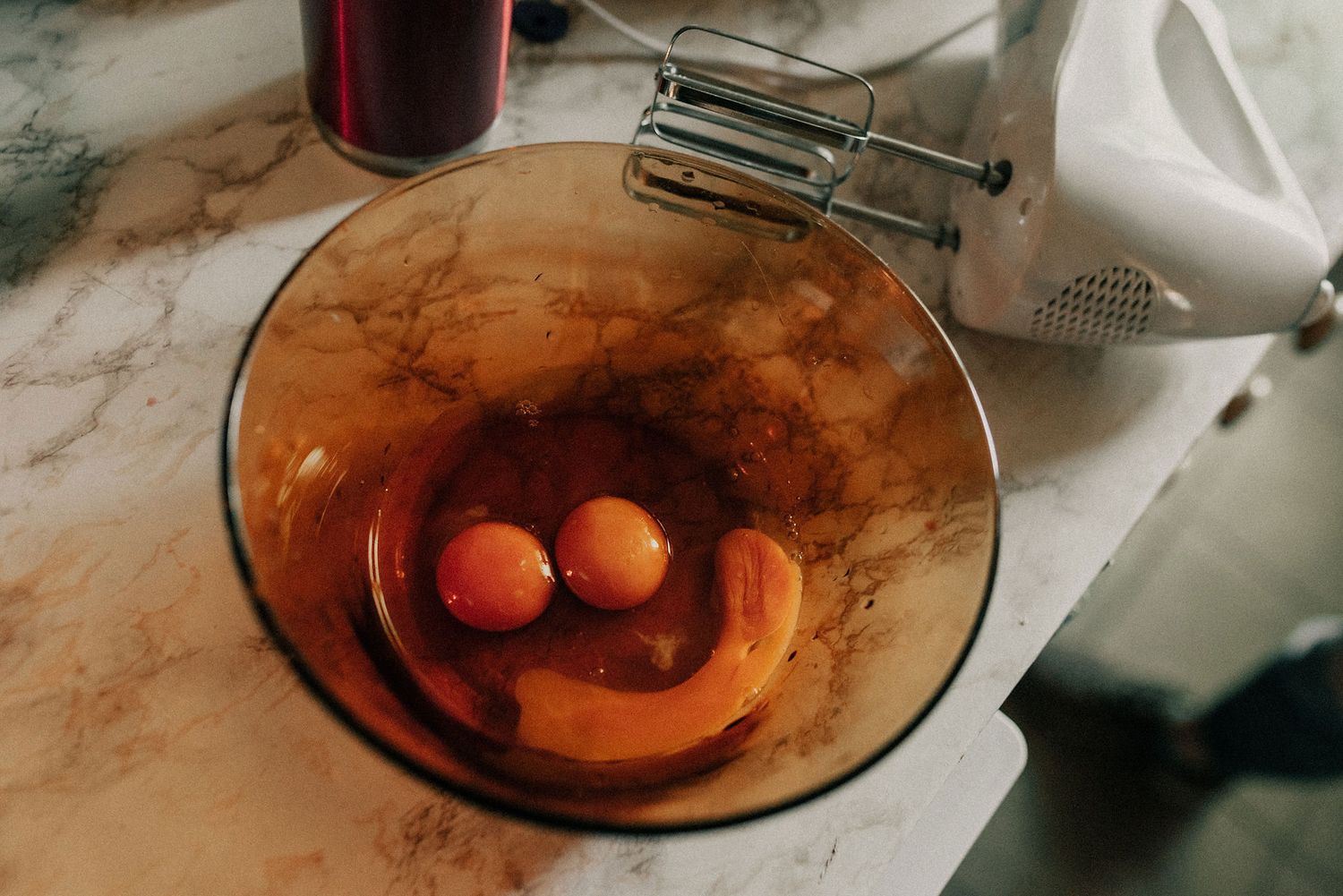 A sequence of photos showing eggs being cracked and beaten in an amber glass mixing bowl.