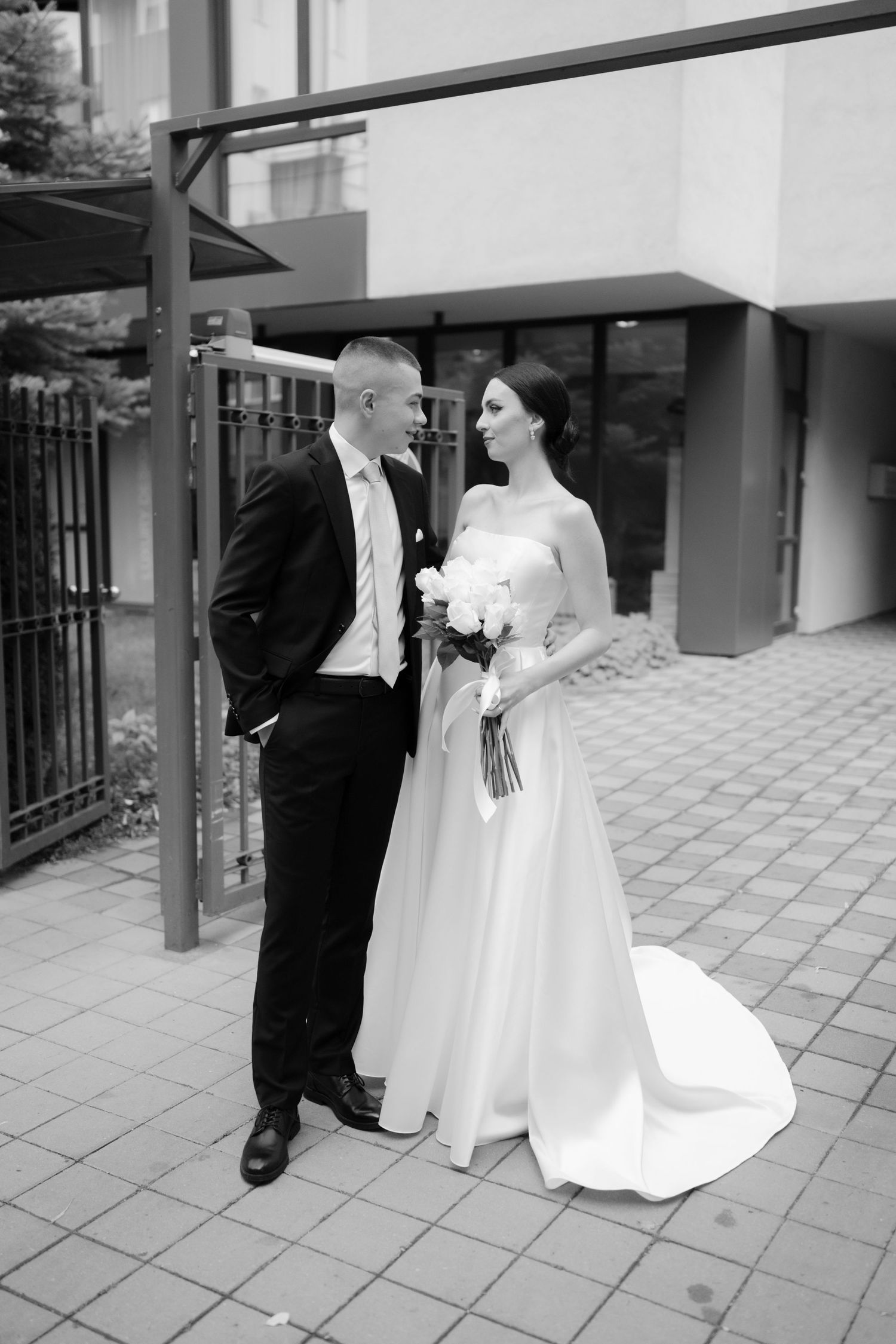 Black and white wedding photography series showing couple in formal attire dancing together on outdoor patio.