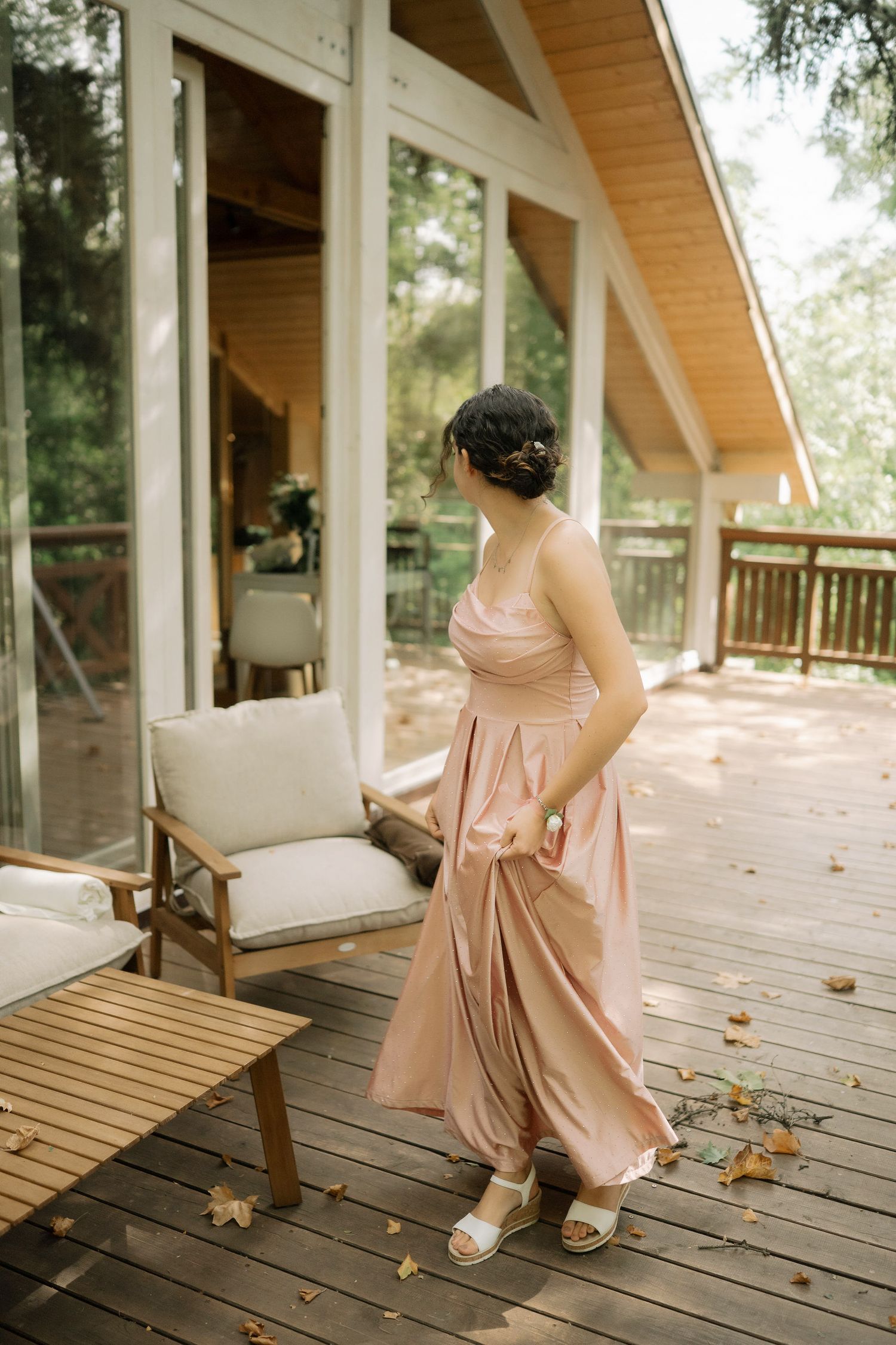 A sequence of photos capturing movement in a pink dress on a rustic wooden deck with fallen leaves.