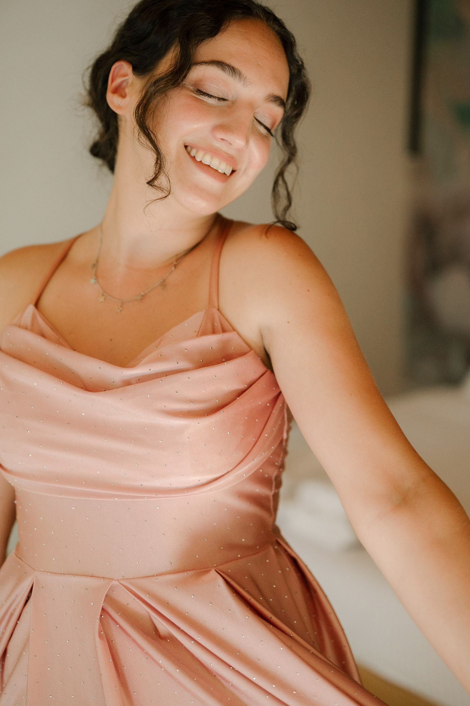 A sequence of photos showing someone in a blush pink satin dress smiling and looking down in soft lighting.