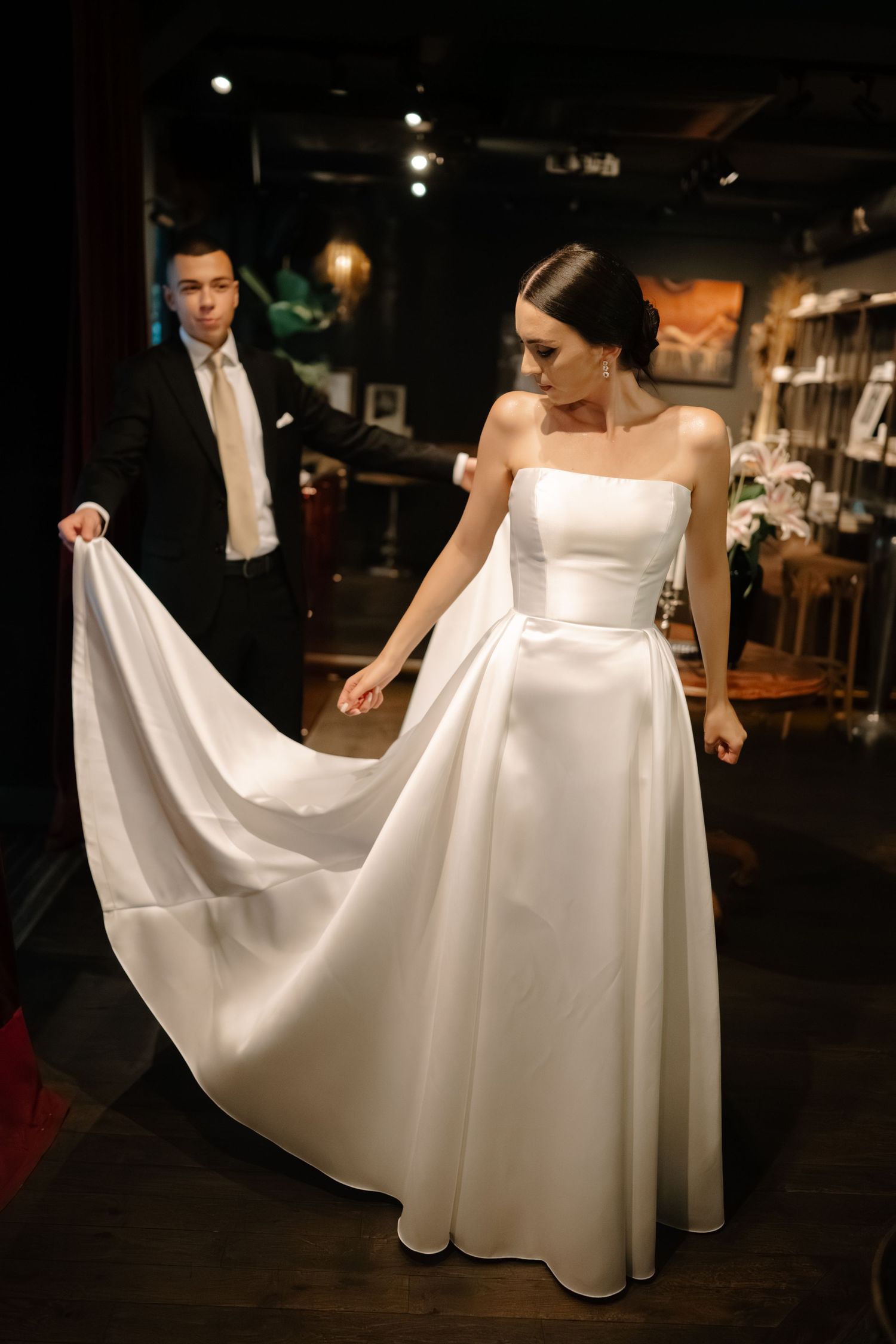 A series of wedding dress shots showing the elegant flow and movement of a white gown's fabric in a dimly lit venue.